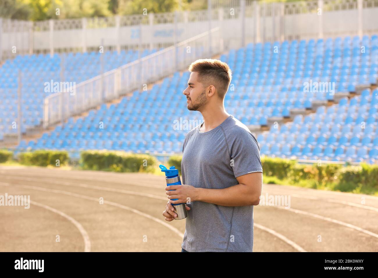 Sporty man with bottle of water at the stadium Stock Photo - Alamy