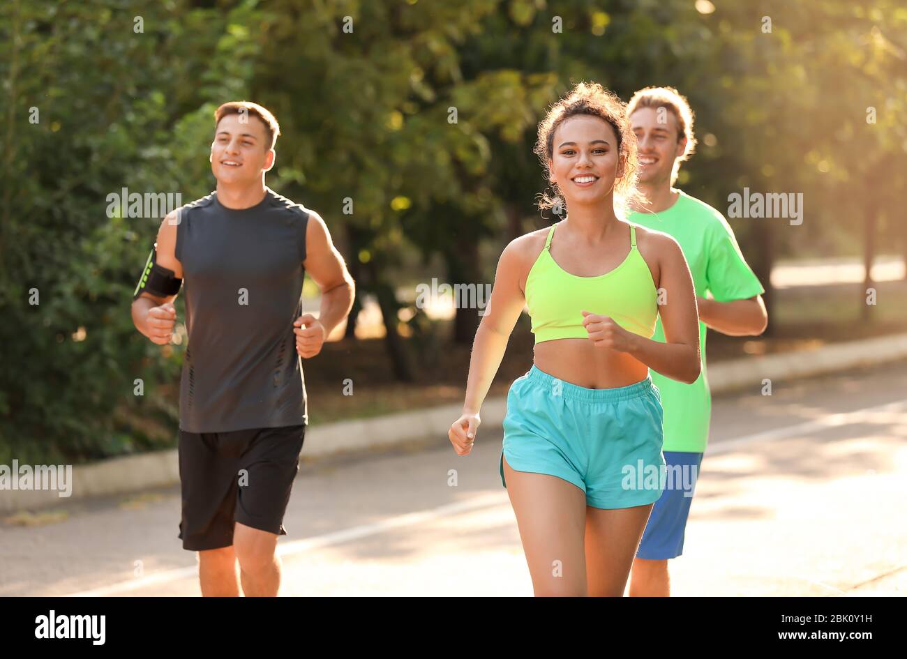 Group of sporty young people running outdoors Stock Photo - Alamy