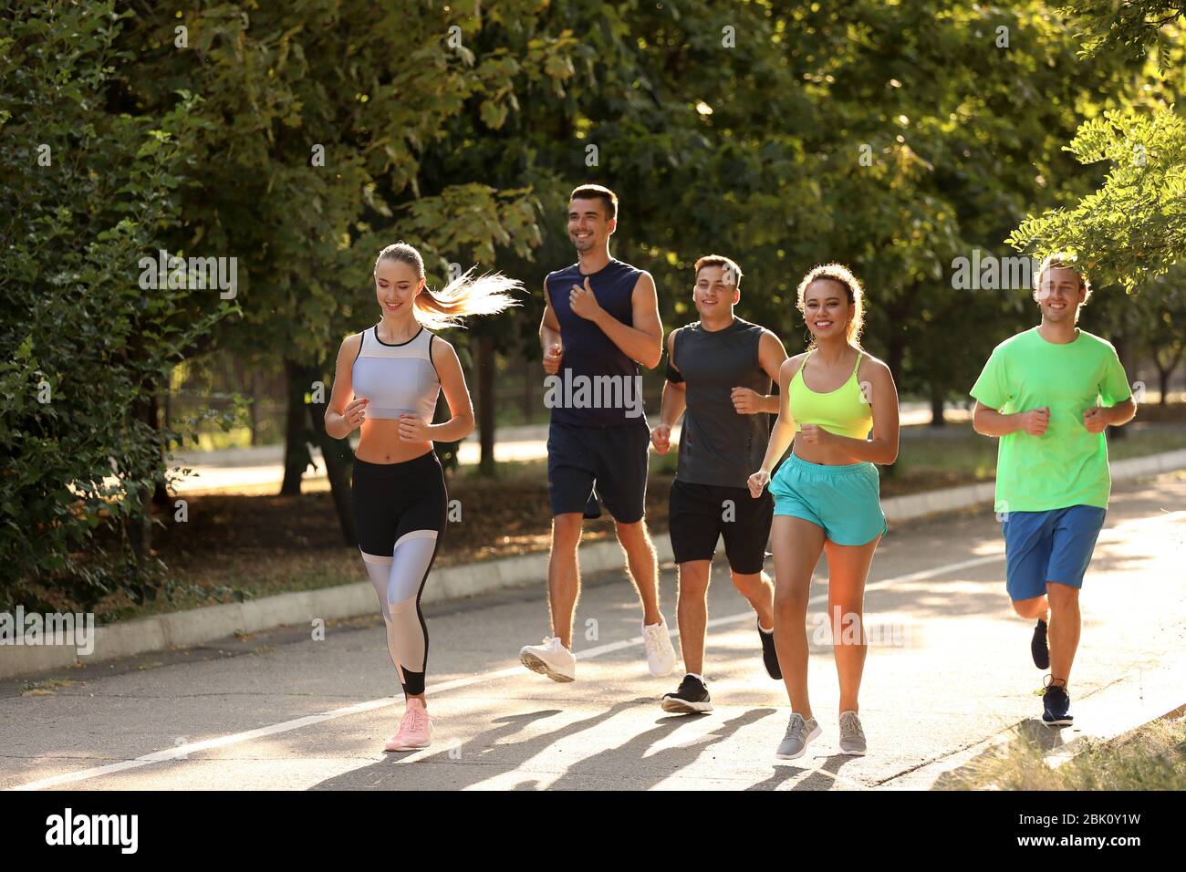 Group of sporty young people running outdoors Stock Photo - Alamy
