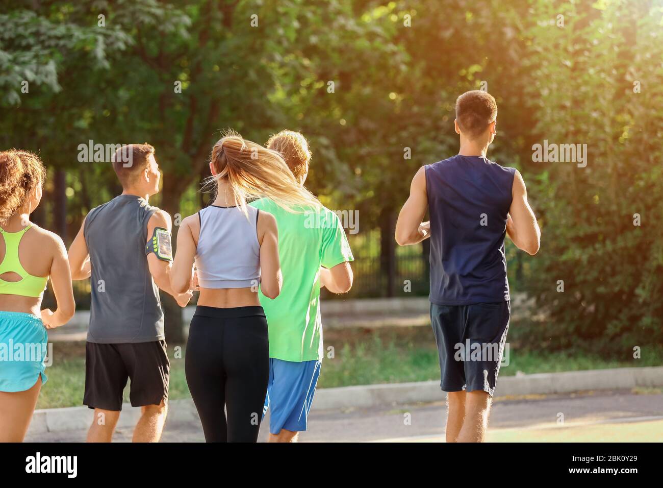 Group of sporty young people running outdoors Stock Photo - Alamy