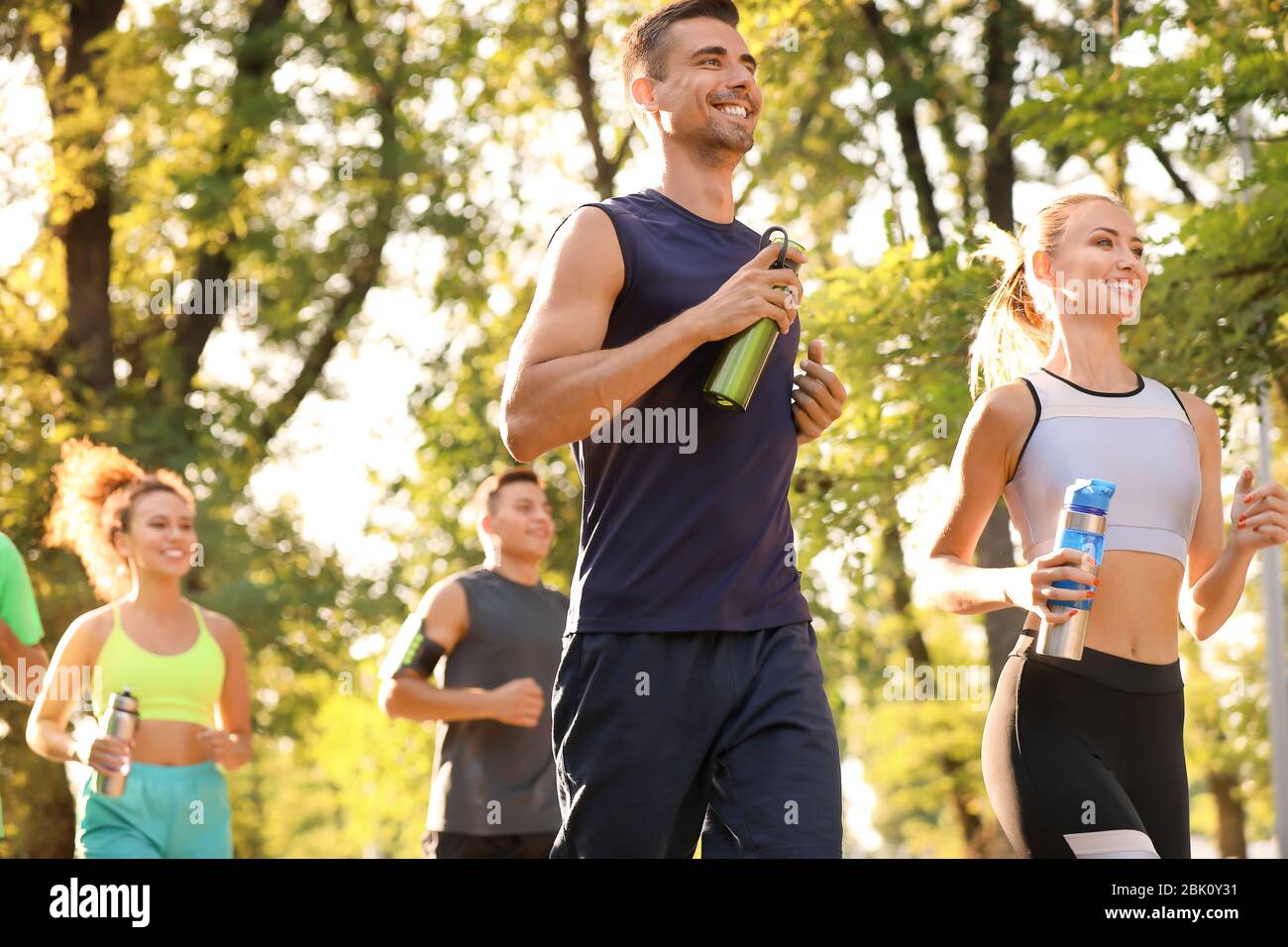 Group of sporty young people running outdoors Stock Photo - Alamy