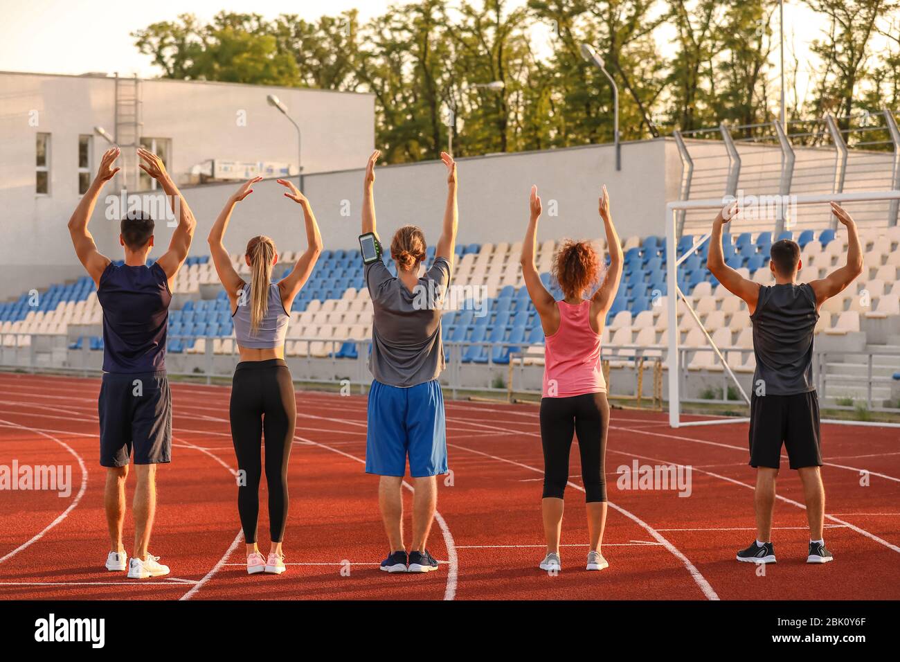 Group of sporty young people training at the stadium Stock Photo - Alamy