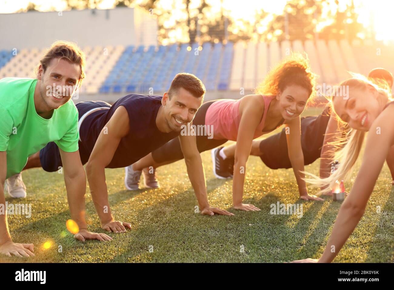 Group of sporty young people training at the stadium Stock Photo - Alamy