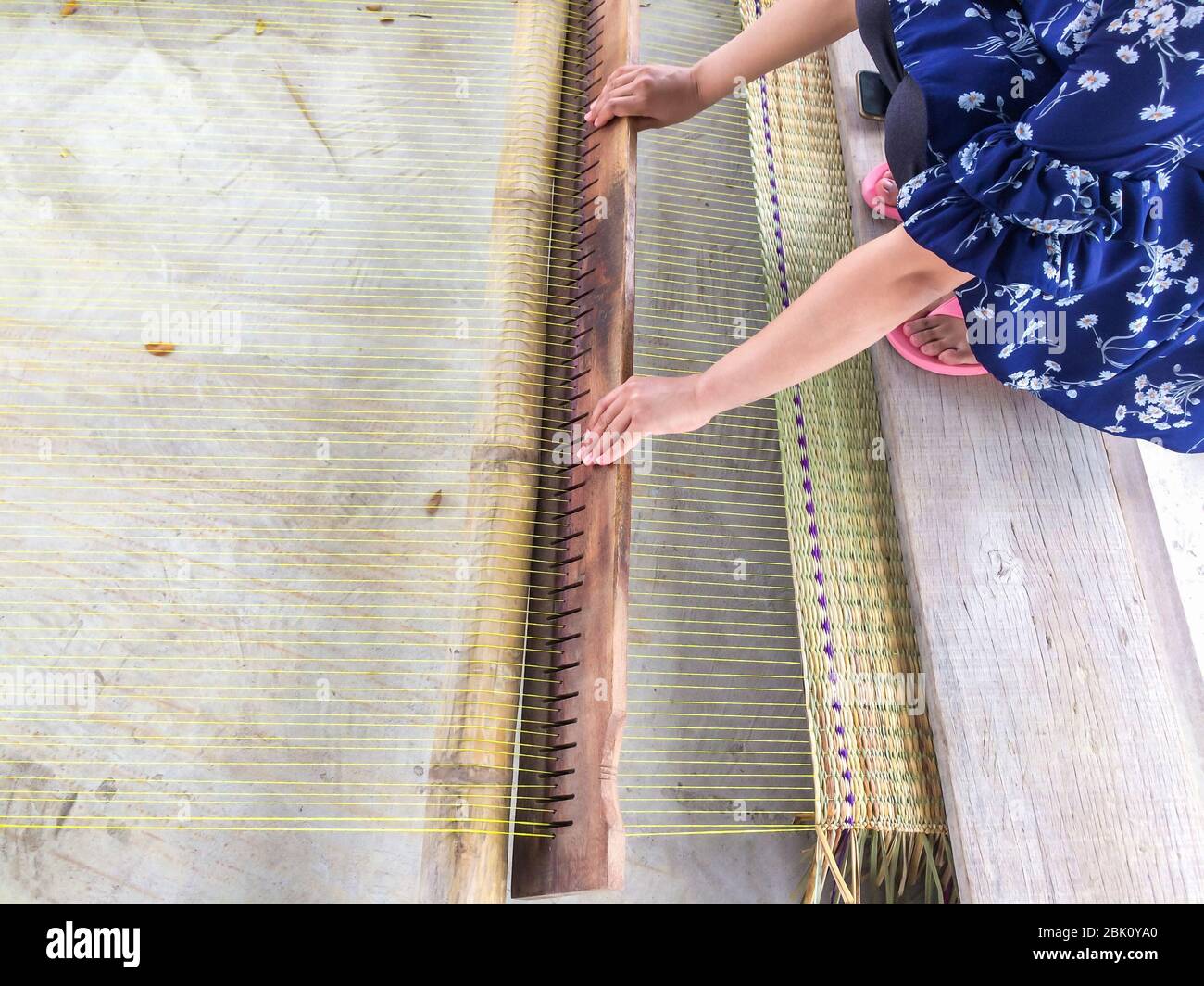 The hands of women woven mats traditional are products handmade in countryside of Thailand. Stock Photo