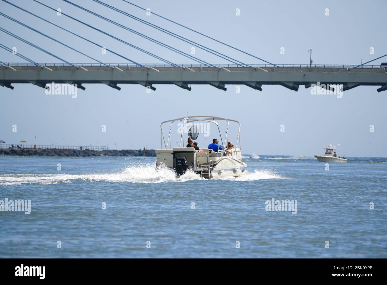 Bethany Beach, Delaware, U.S.A - September 2, 2019 - A pontoon boat on the move under the Indian River bridge Stock Photo
