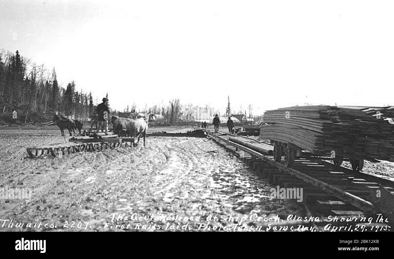 Horses pulling sleds over mud and first rails laid for the Alaska Railroad at Ship Creek April 29 1915 Stock Photo