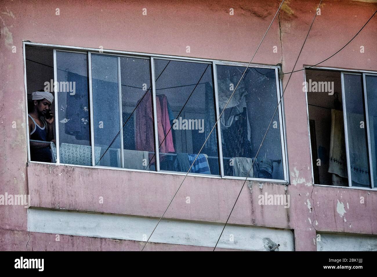 Kochi, India - March 2020: A man speaking on the phone from his home during Indian confinement until May 3 on March 28, 2020 in Kochi, Kerala, India. Stock Photo