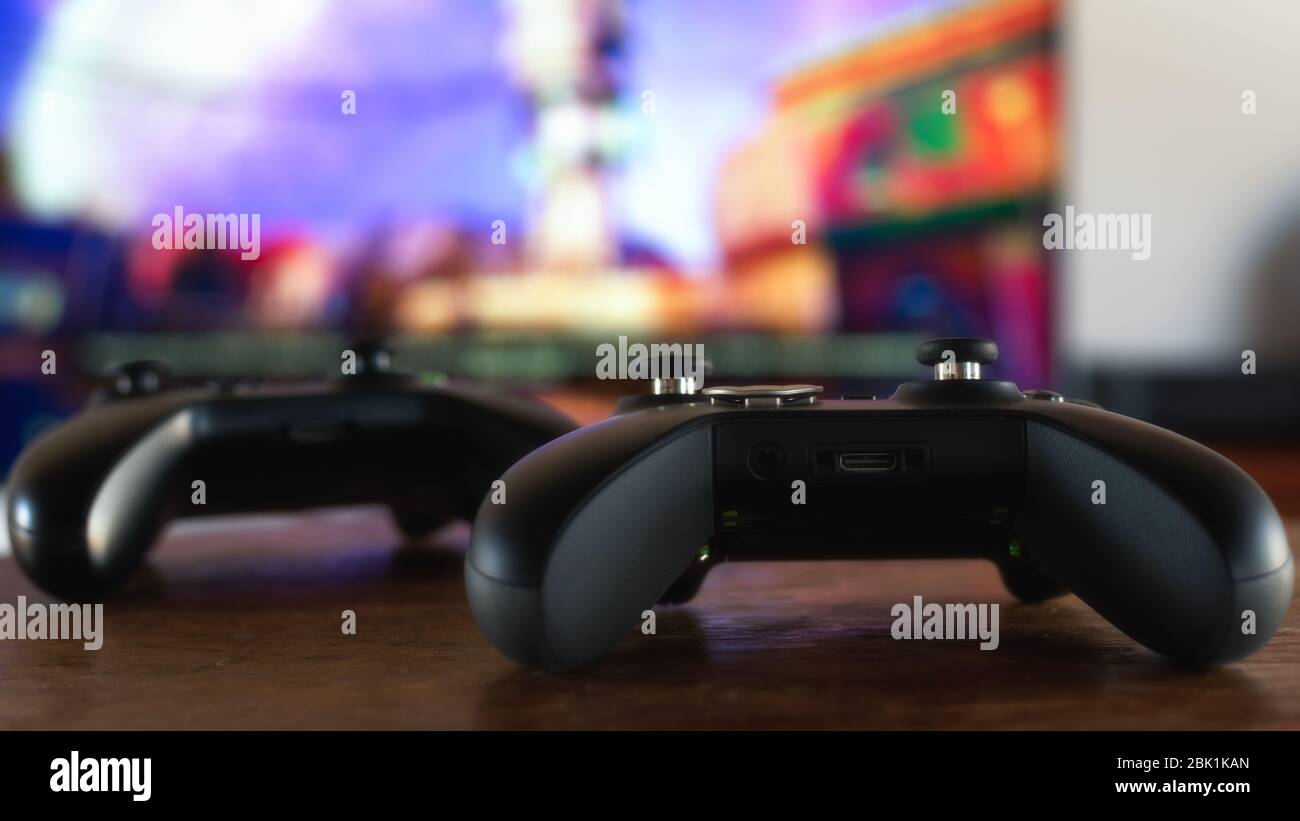 Two gamepad with a video game in background. Video gaming concept. Shallow depth of field image. Stock Photo