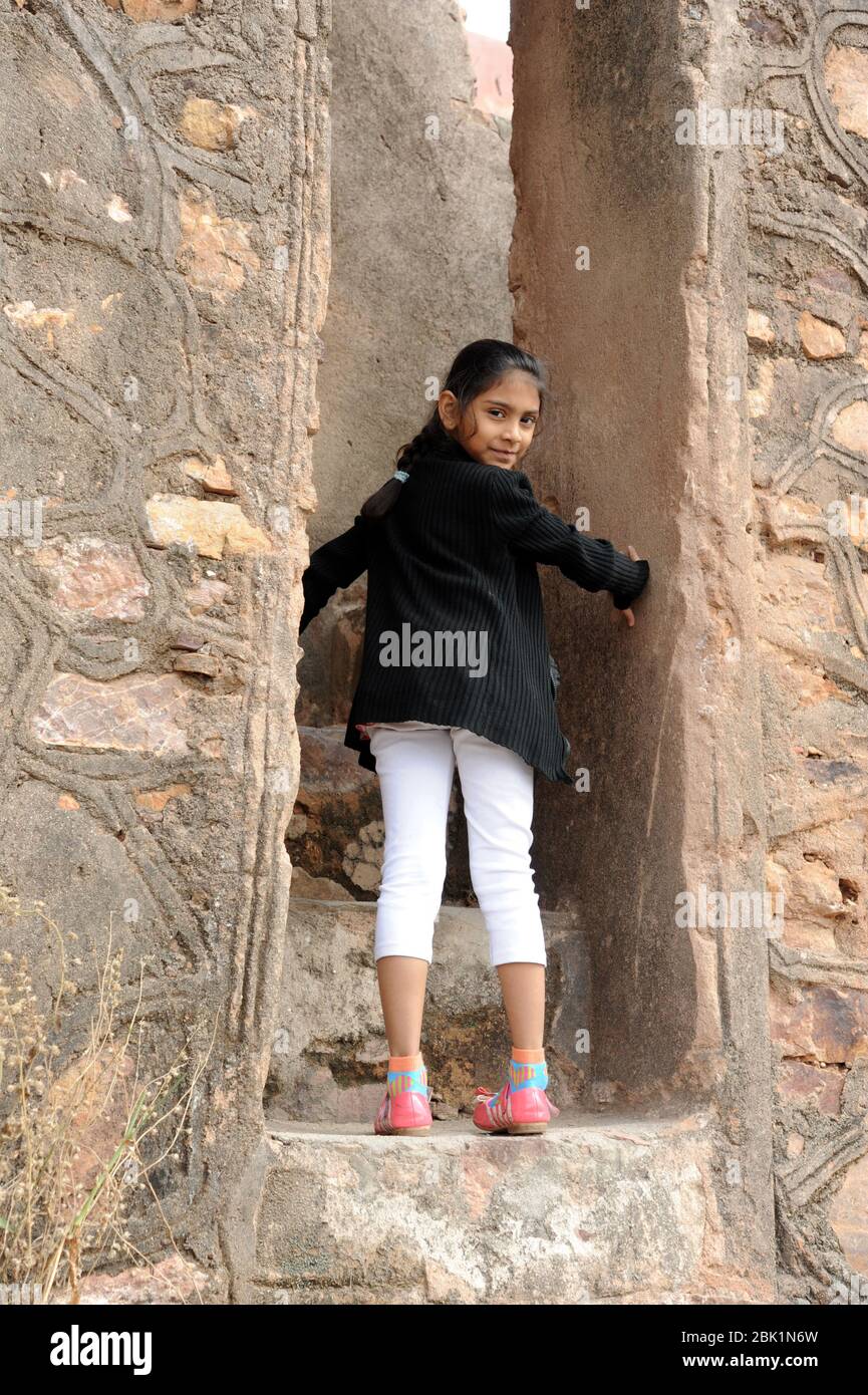 Nathdwara, Rajasthan, India, Asia - Jan. 23, 2014 - Indian happy little cute girl climbing steps Stock Photo