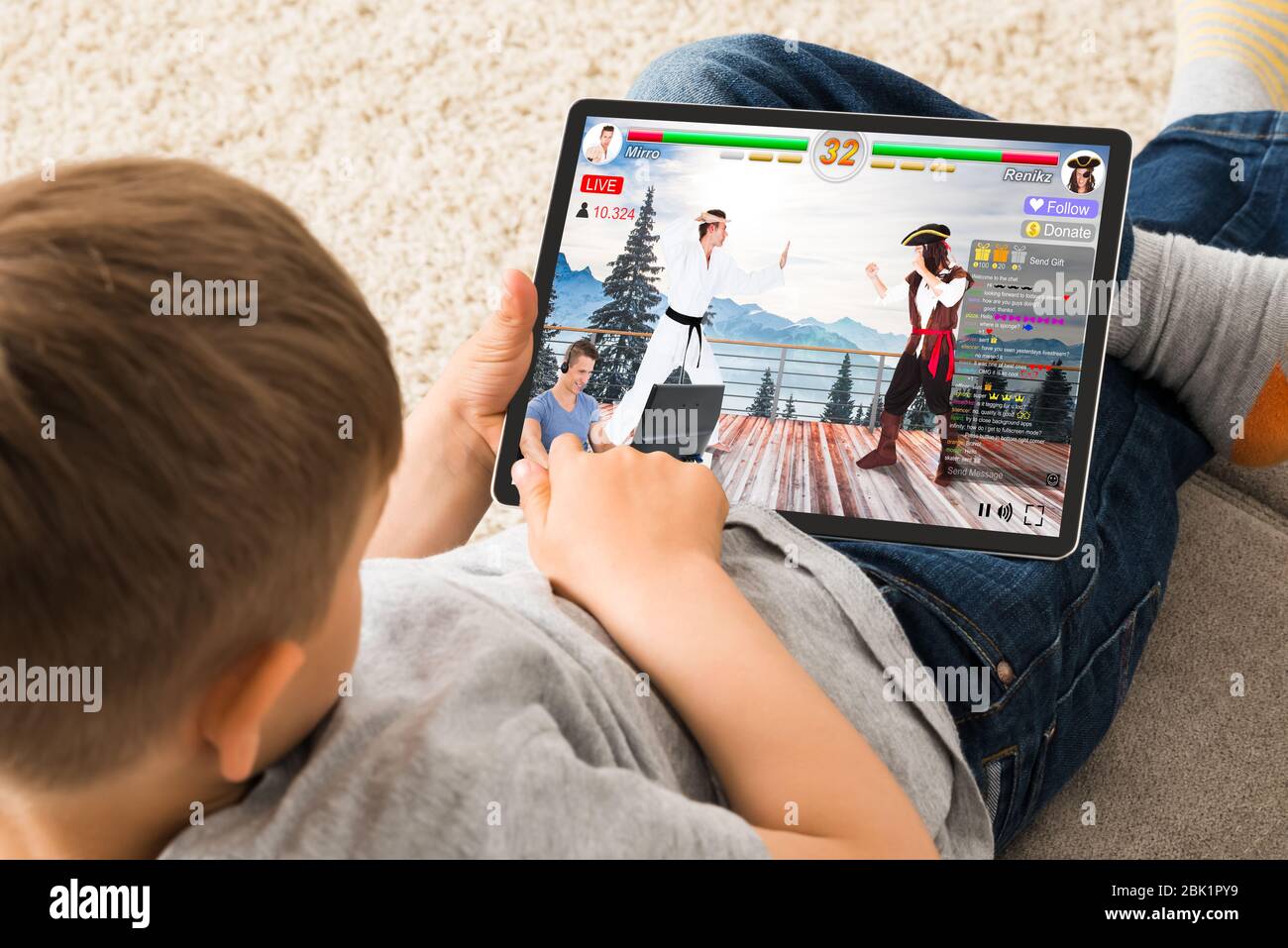 Kid Watching Live Game Streaming Session On Tablet Computer Stock Photo