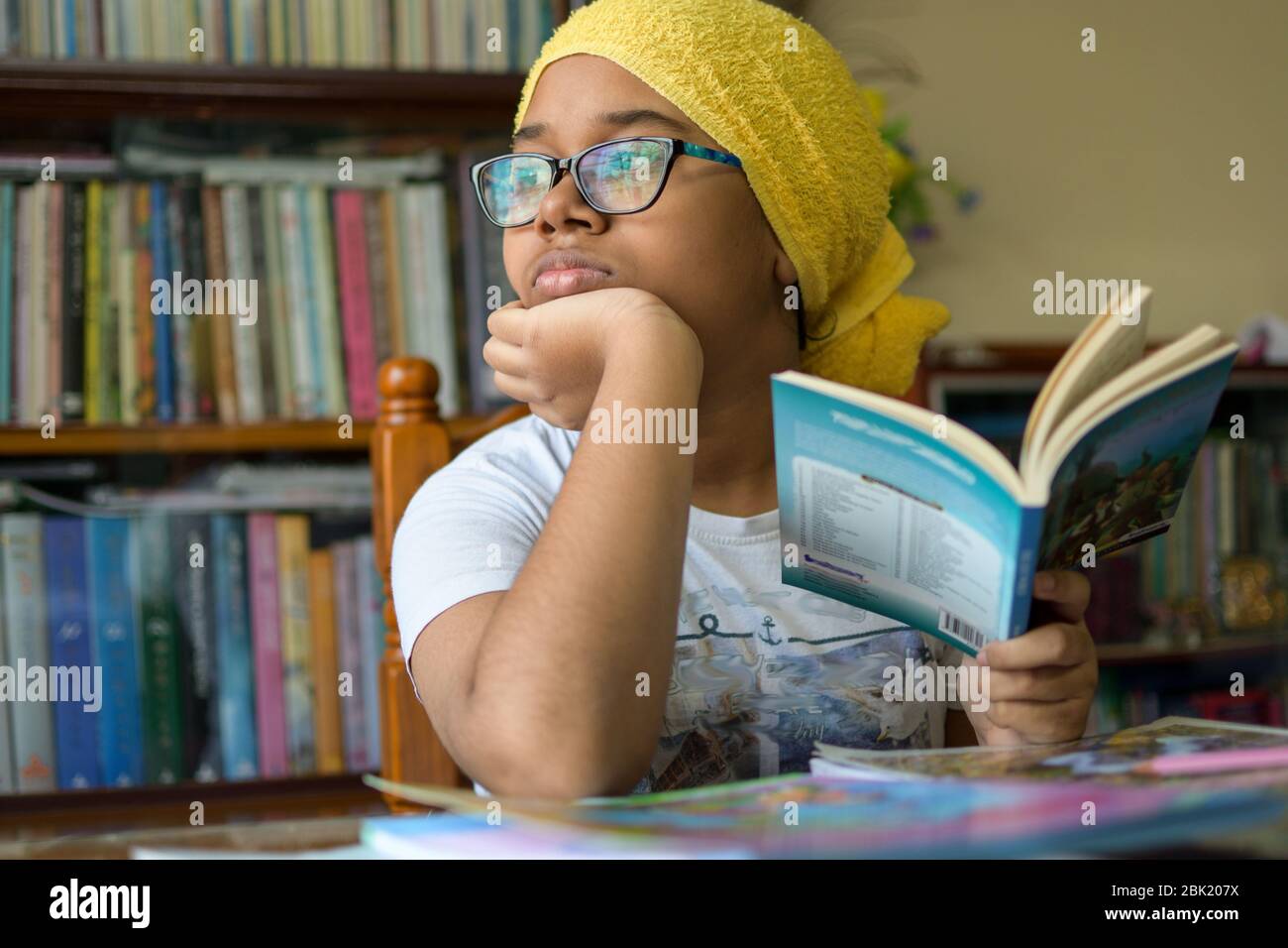 Cute little Indian school girl studying at home during lock down period due to Corona Virus pandemic Stock Photo