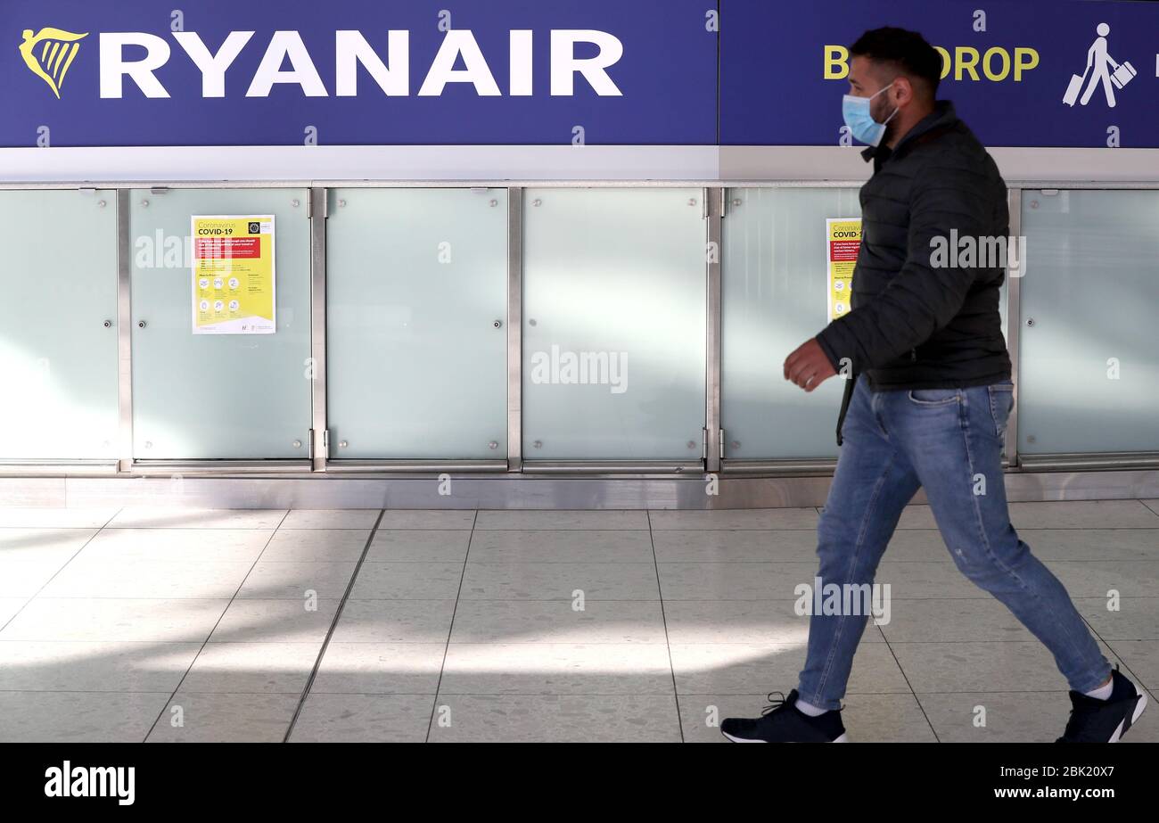 A man walks past a Ryanair sign in terminal one at Dublin airport. The  budget airline group has announced that up to 3,000 jobs across pilots and cabin  crew will be cut