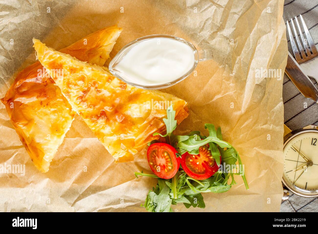 Cheese pie served with bowl of yogurt and rocket salad. Stock Photo
