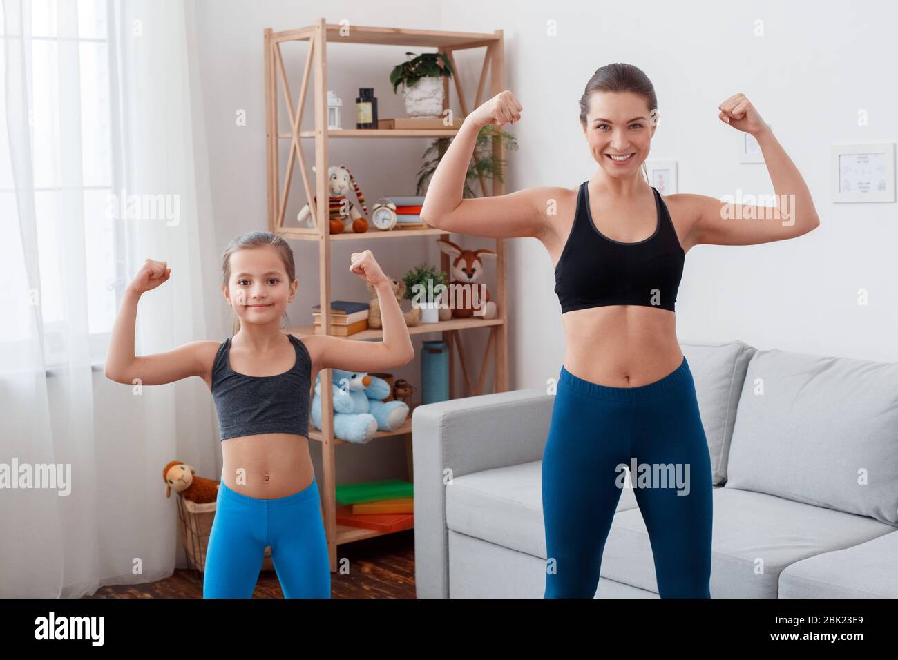 Young adult mom with her daughter making sport training together at home  Stock Photo - Alamy