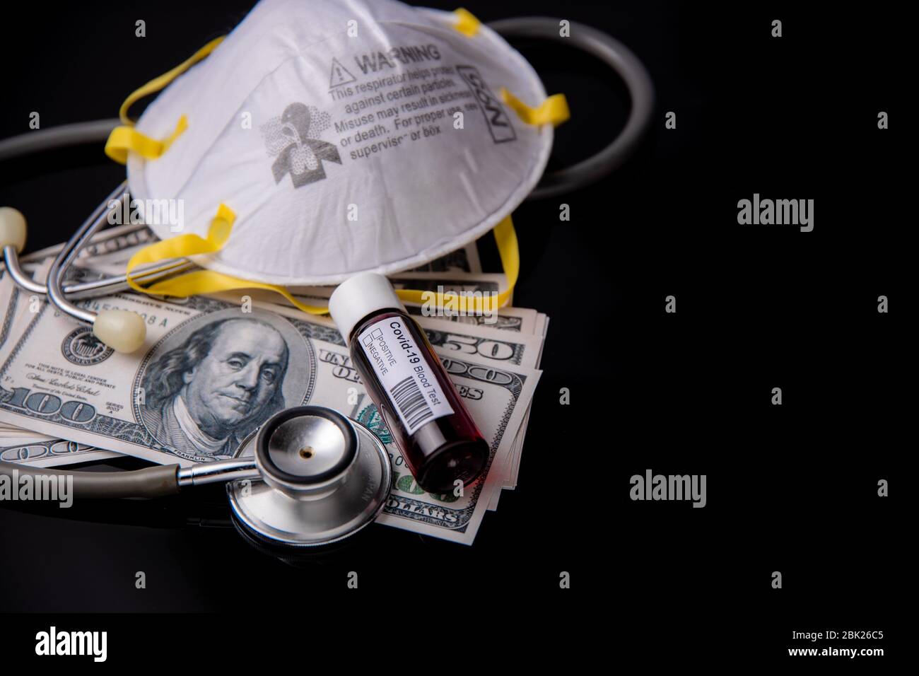 Concept of economy crisis and recession in USA during coronavirus or covid-19 pandemic with N95 mask US dollars stethoscope and black background Stock Photo
