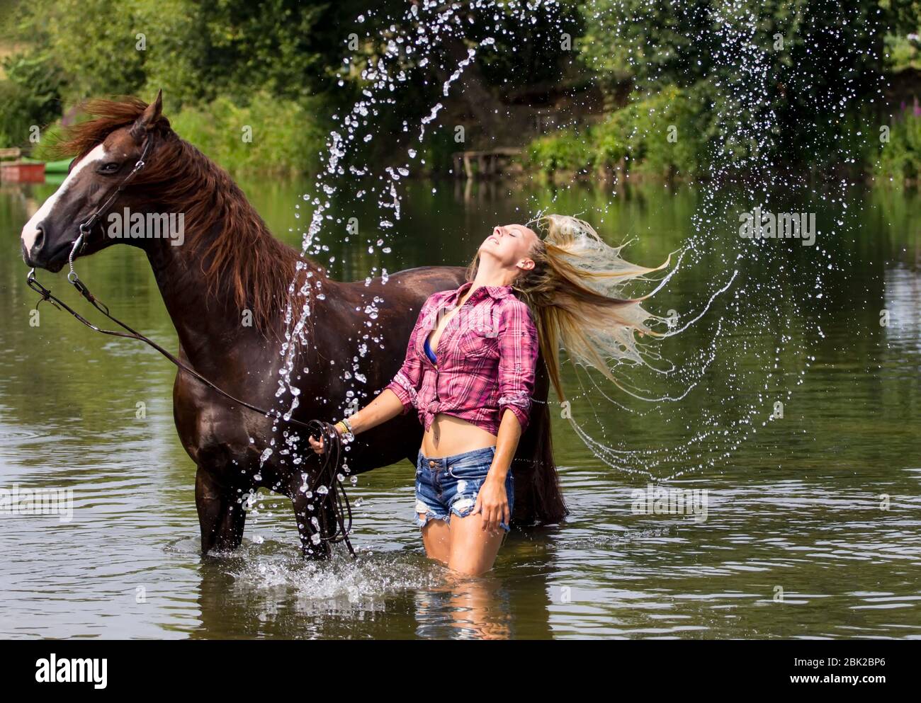 Beautiful, sexy blonde cowgirl with her horse in the water Stock Photo Alamy