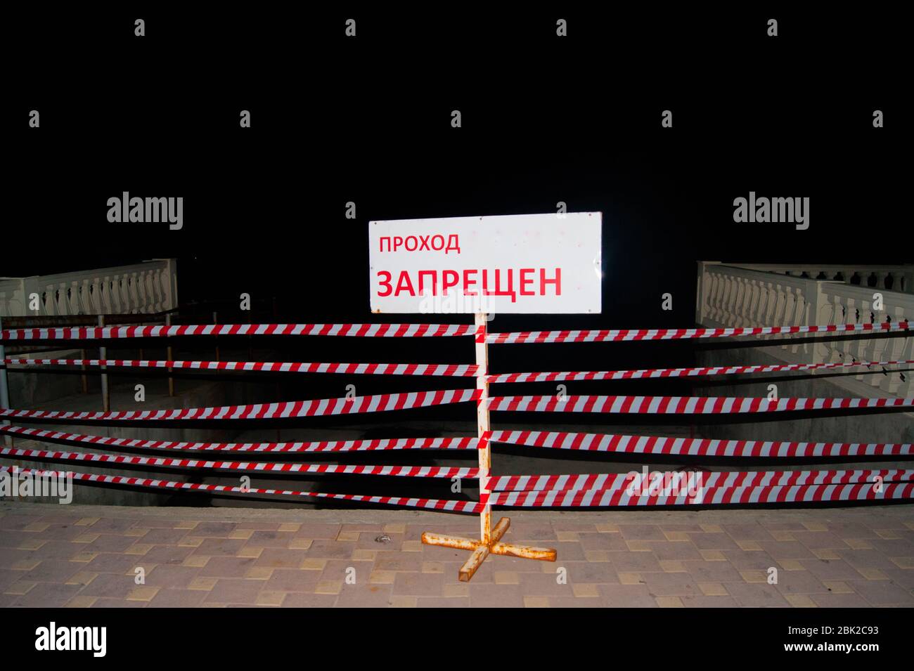 Closed path, no passage. Banner with the inscription - translated into Russian: passage is prohibited. The path is enclosed by a barrier tape. Stock Photo