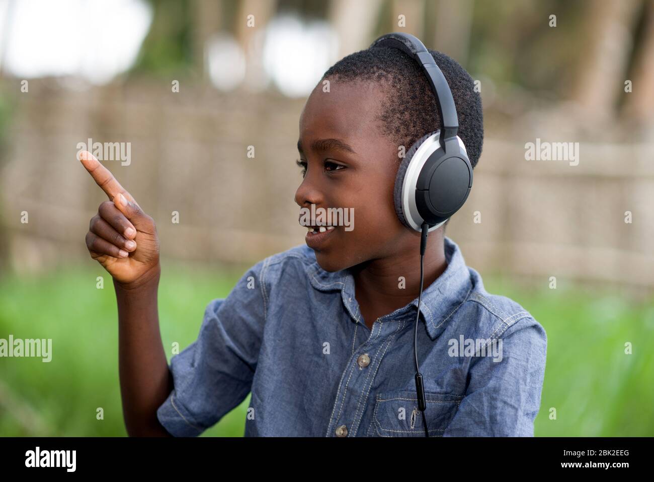 a little boy in the headphones listens to the music and smiles with his index finger up Stock Photo Alamy