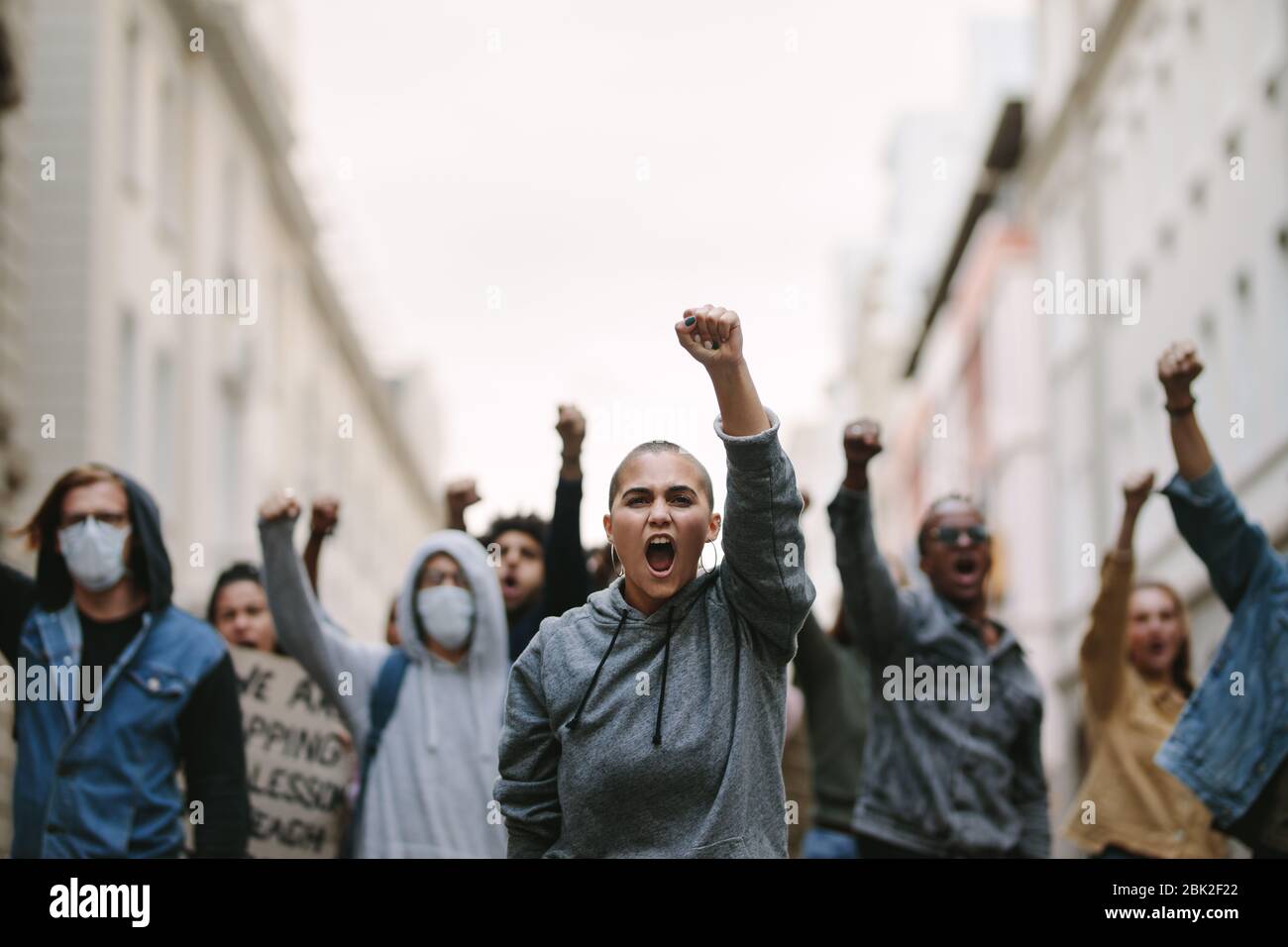 Group of people protesting and giving slogans in a rally. Group of demonstrators protesting in the city. Stock Photo