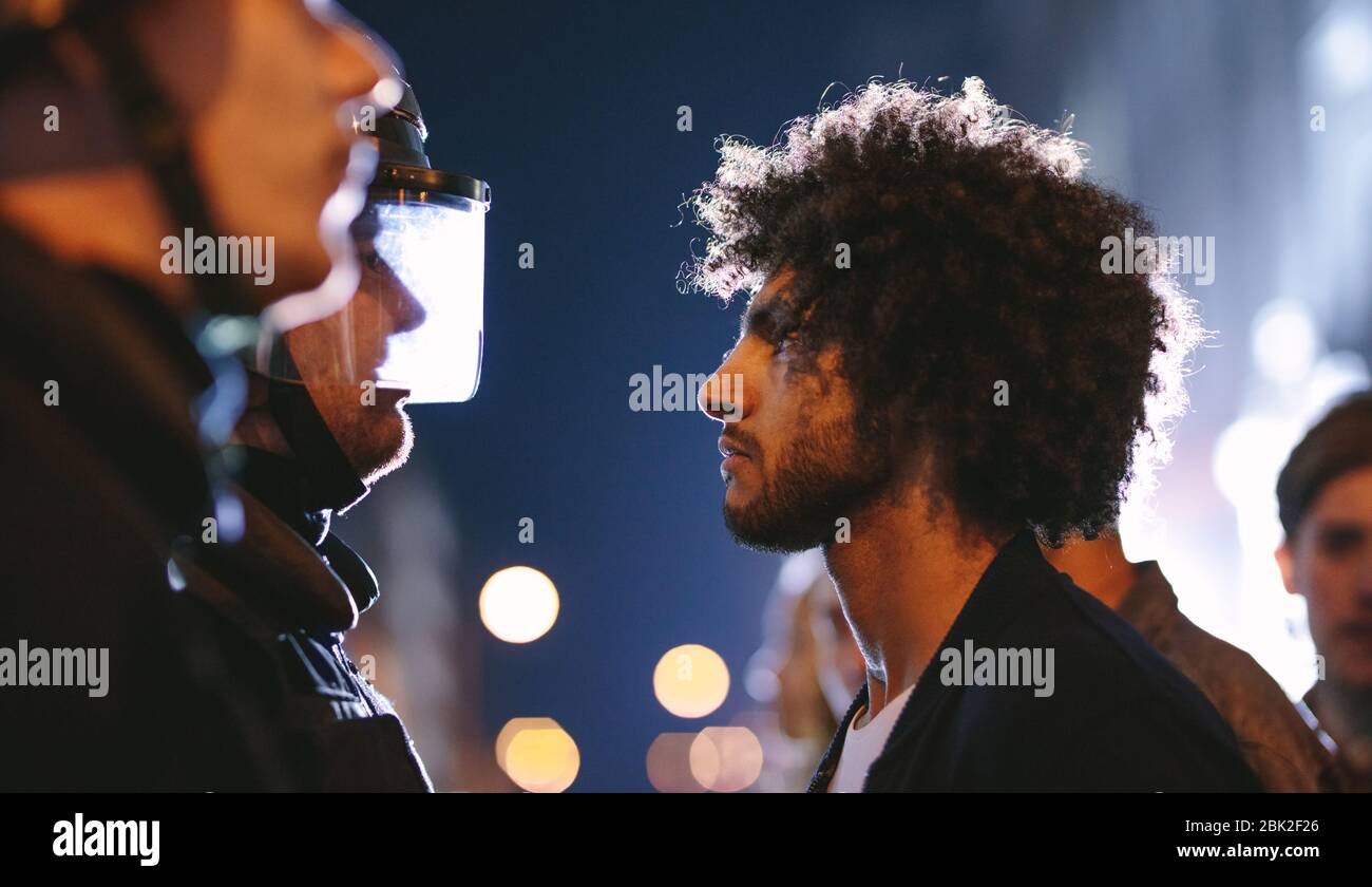 Protestors standing in front of police. Group of people demonstrating against police force. Stock Photo