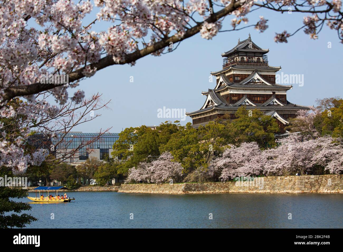 beautiful landscape of Hiroshima Castle with a boat on moat and cherry blossoms in spring, Naka Ward, Hiroshima, Japan Stock Photo