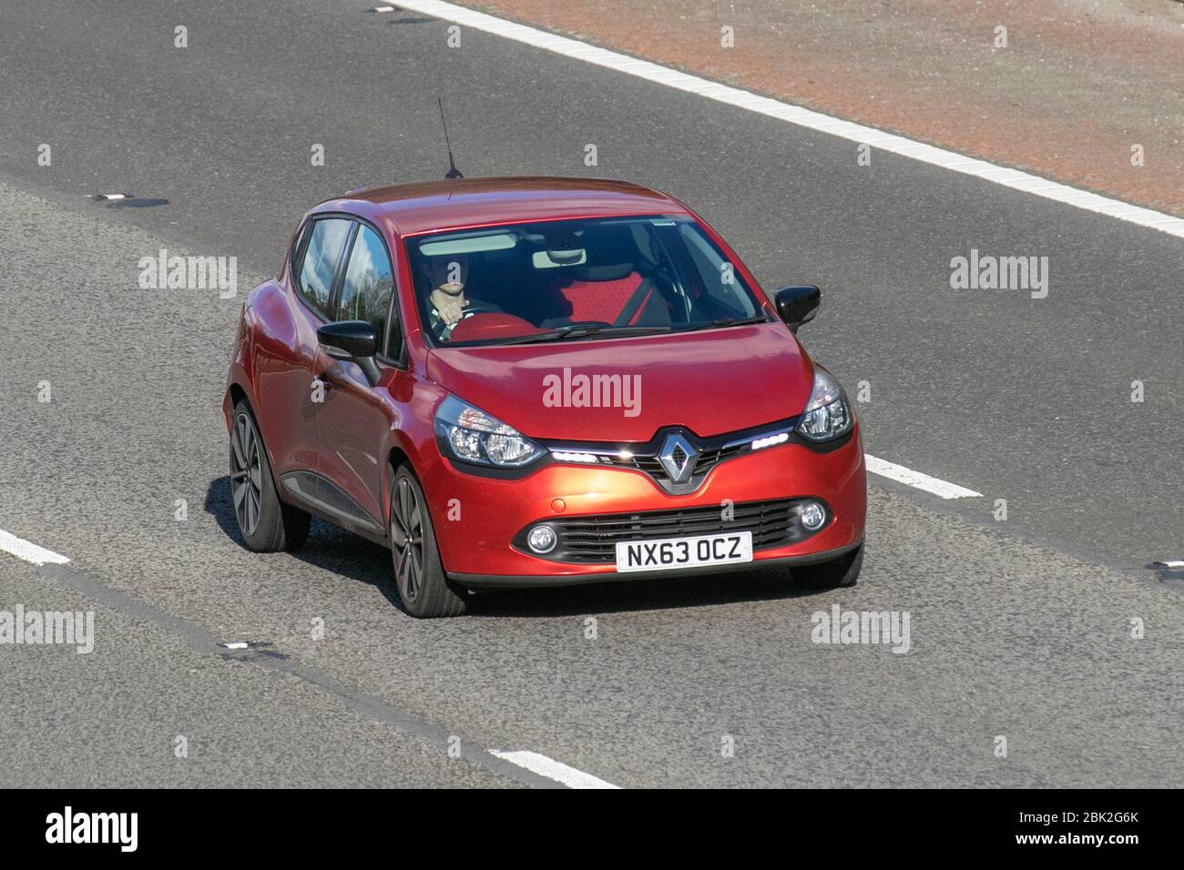 2013 red Renault Clio D-QUE S M-Nav NRG DC; Vehicular traffic moving vehicles, driving vehicle on UK roads, motors, motoring on the M6 motorway highway Stock Photo