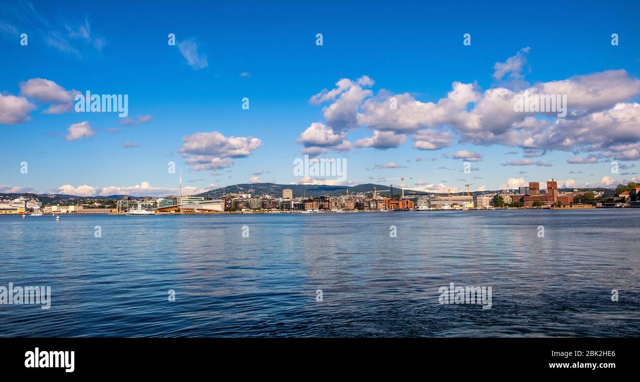 Oslo, Ostlandet / Norway - 2019/09/02: Panoramic view of Oslo waterfront with City Hall, Aker Brygge and Tjuvholmen borough at Pipervika harbor Stock Photo