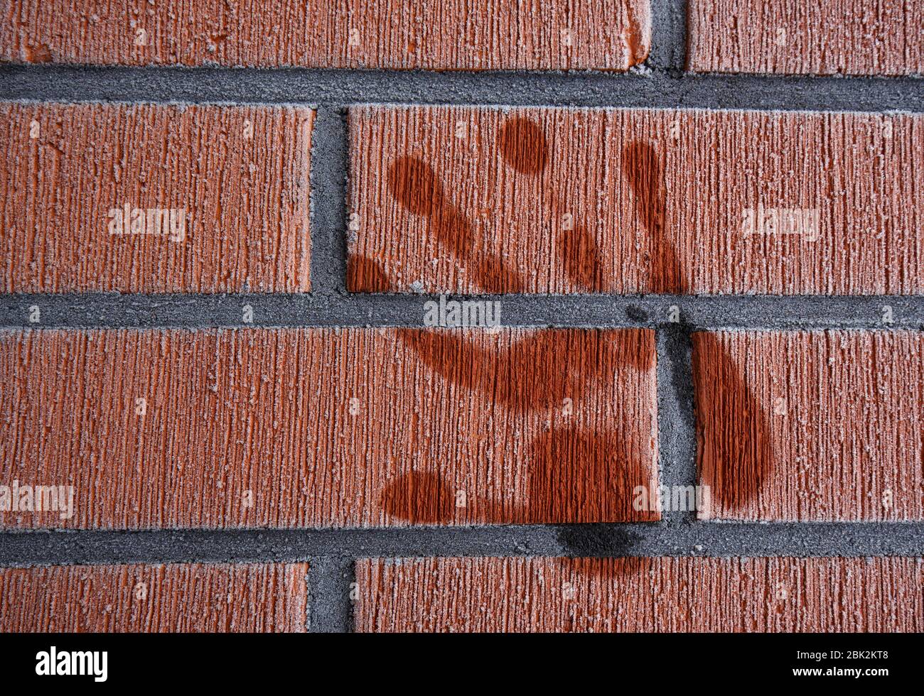 Wet melted palm print on frosty red tile wall at Winter , Finland Stock Photo