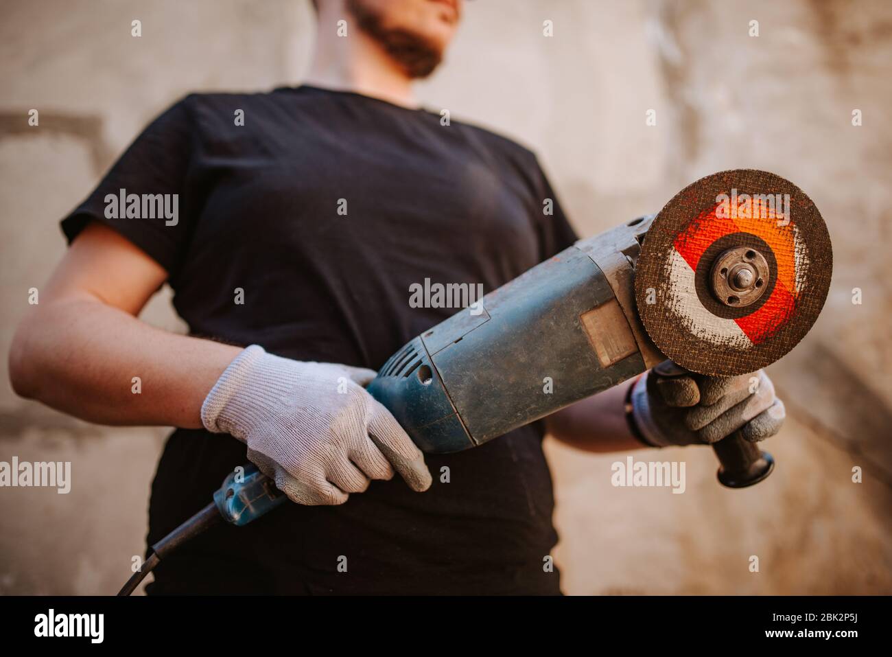 A young caucasian man holds a grinder in his hand Stock Photo