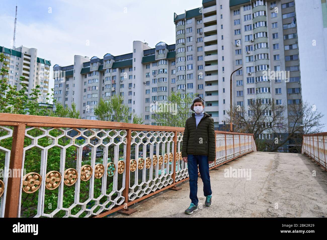 View of teen boy walks down the street during the day, a pedestrian walkway and ...