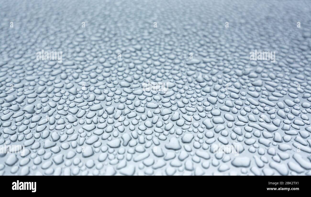 Water drops on silvery metal surface Stock Photo