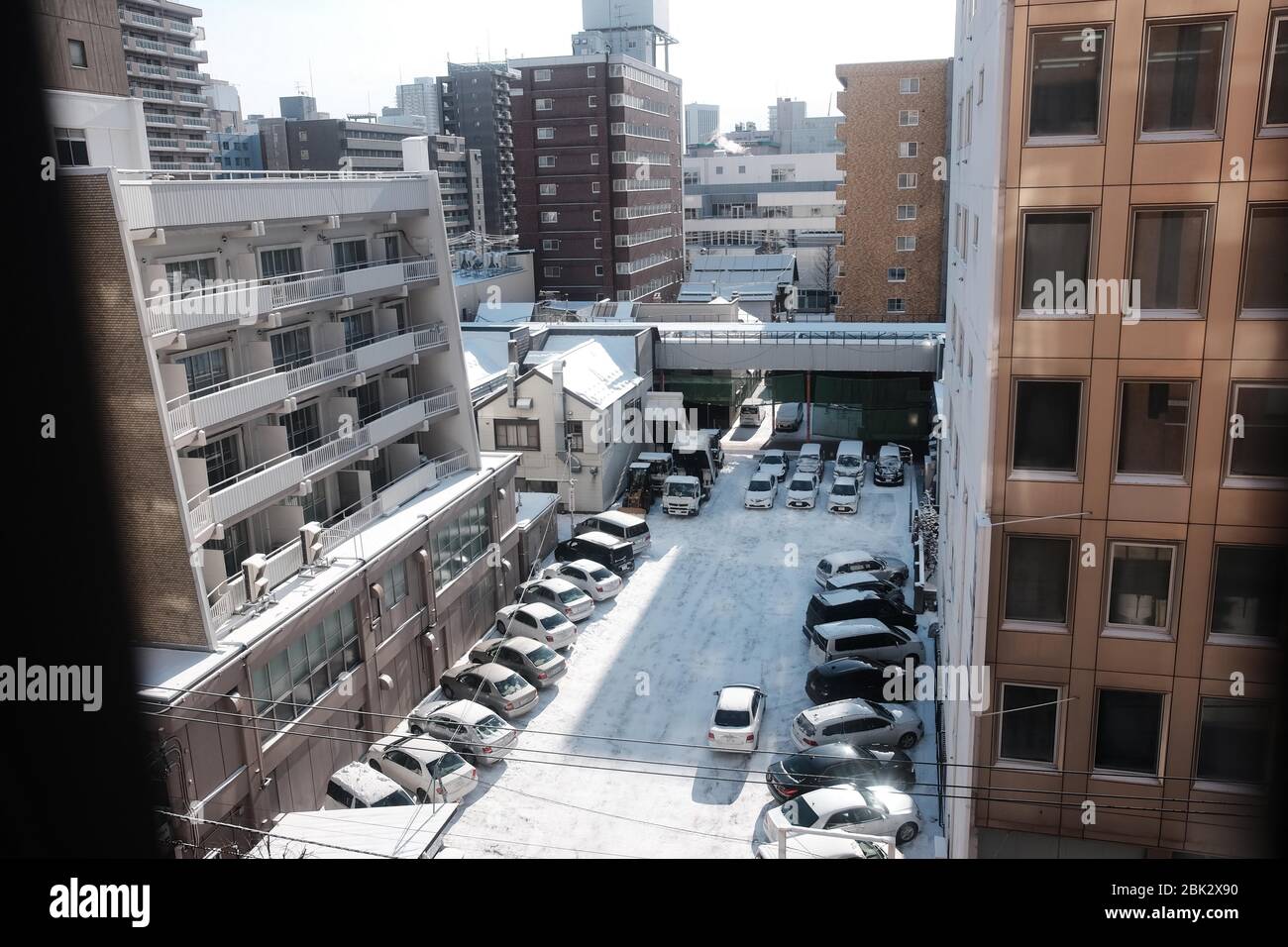 View of Parking Lot between brown Buildings, Sapporo, Hokkaido, Japan Stock Photo