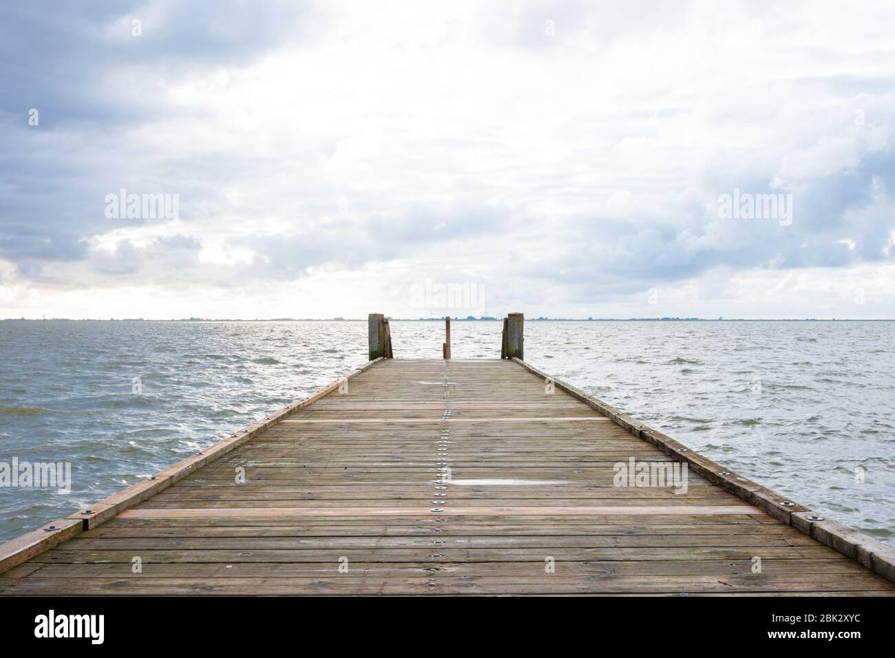 lonely boat dock leads directly into the sea in landscape format Stock Photo