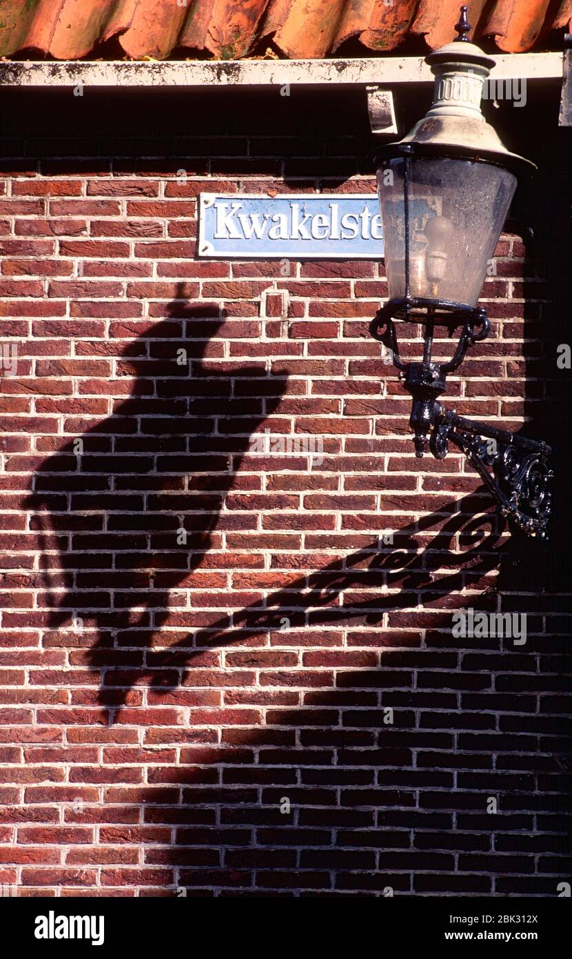 Brick wall, street lantern, wall bracket, casts shadow, street sign, Edam, Provinz of Nordholland, The Netherlands Stock Photo