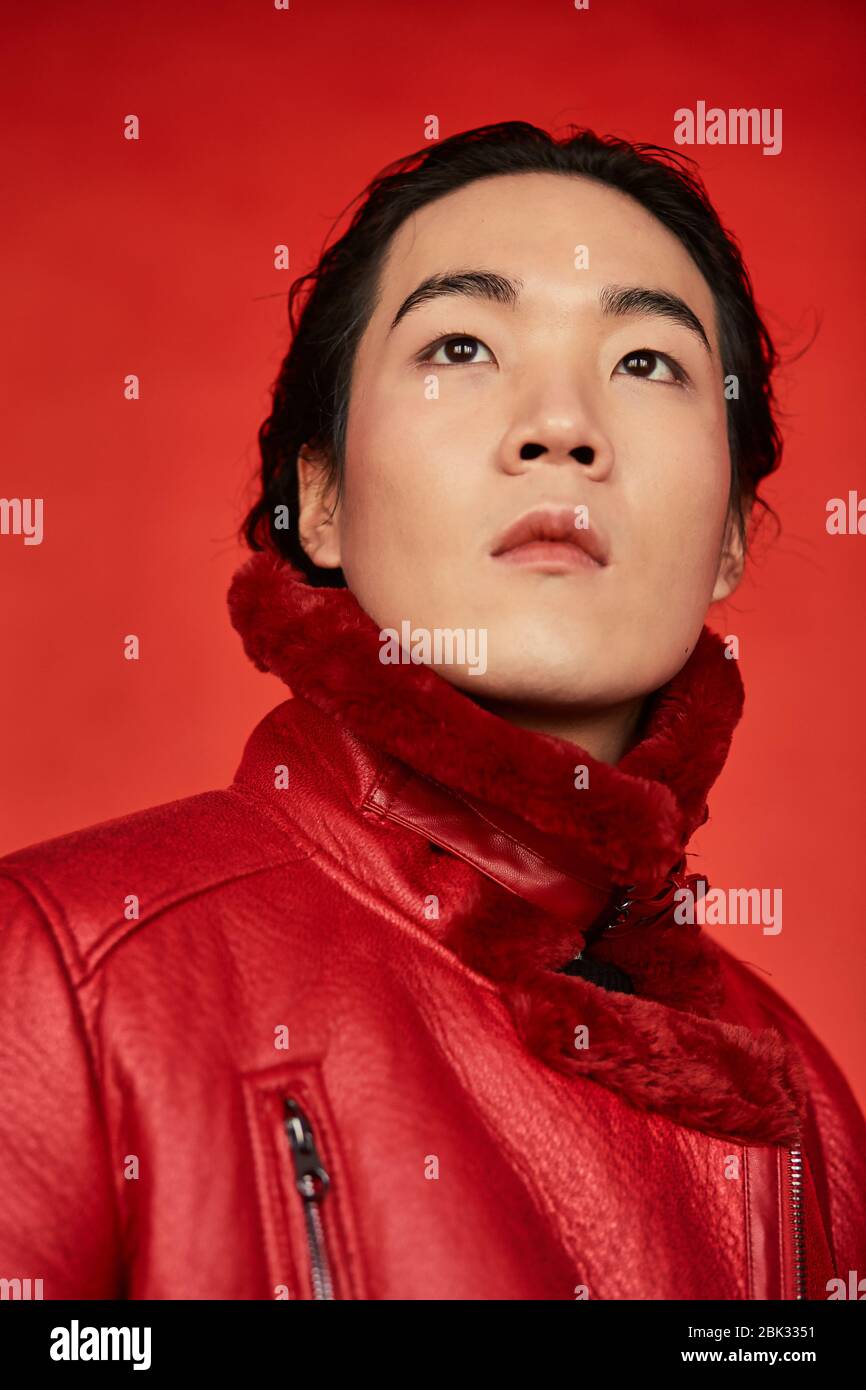 Asian man in red clothes on a red background Stock Photo - Alamy