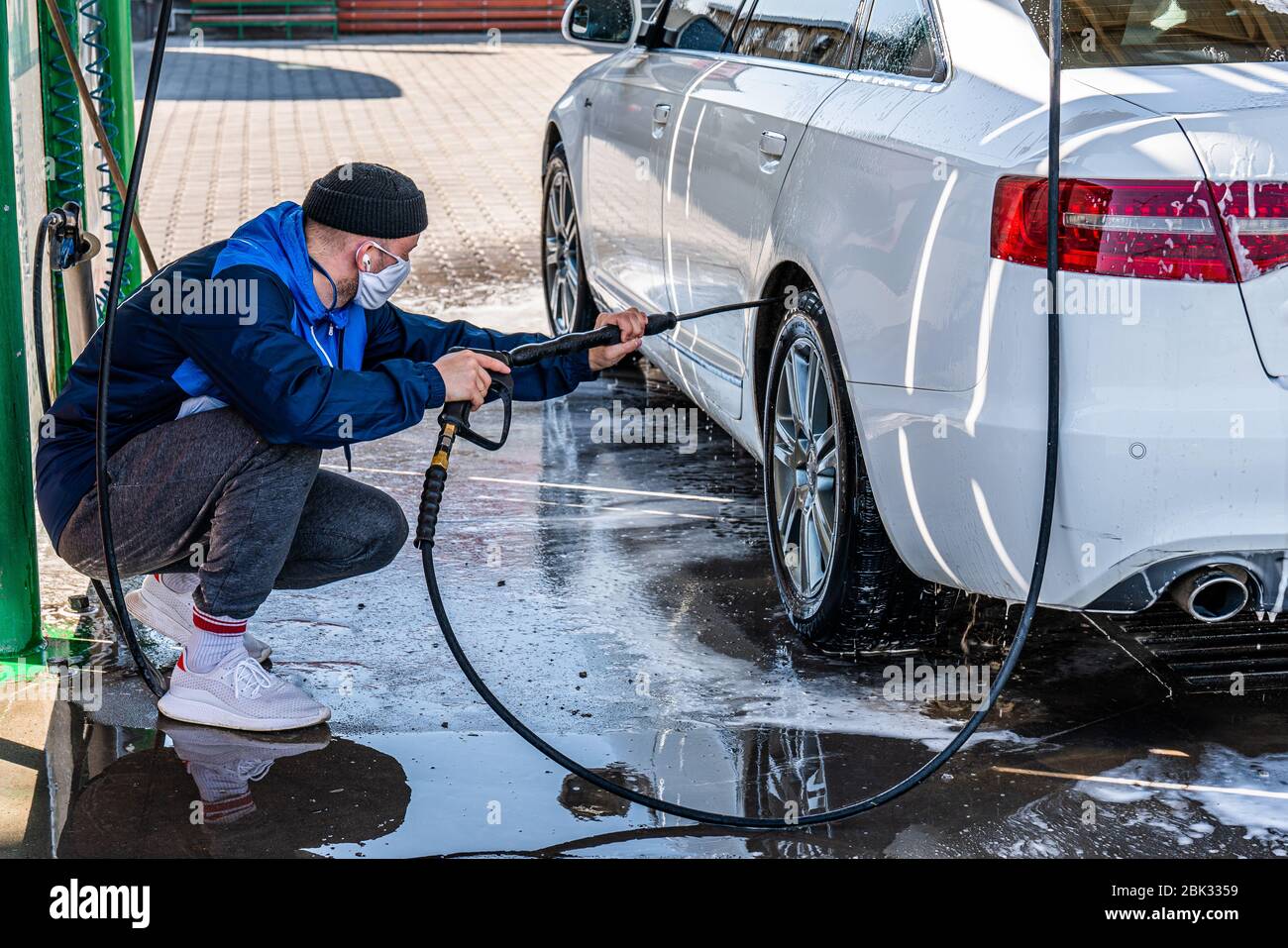 Mann wäscht Auto im Freien. männliche hand hält schlauch mit wasser und  wasserfahrzeug. 8008959 Stock-Photo bei Vecteezy