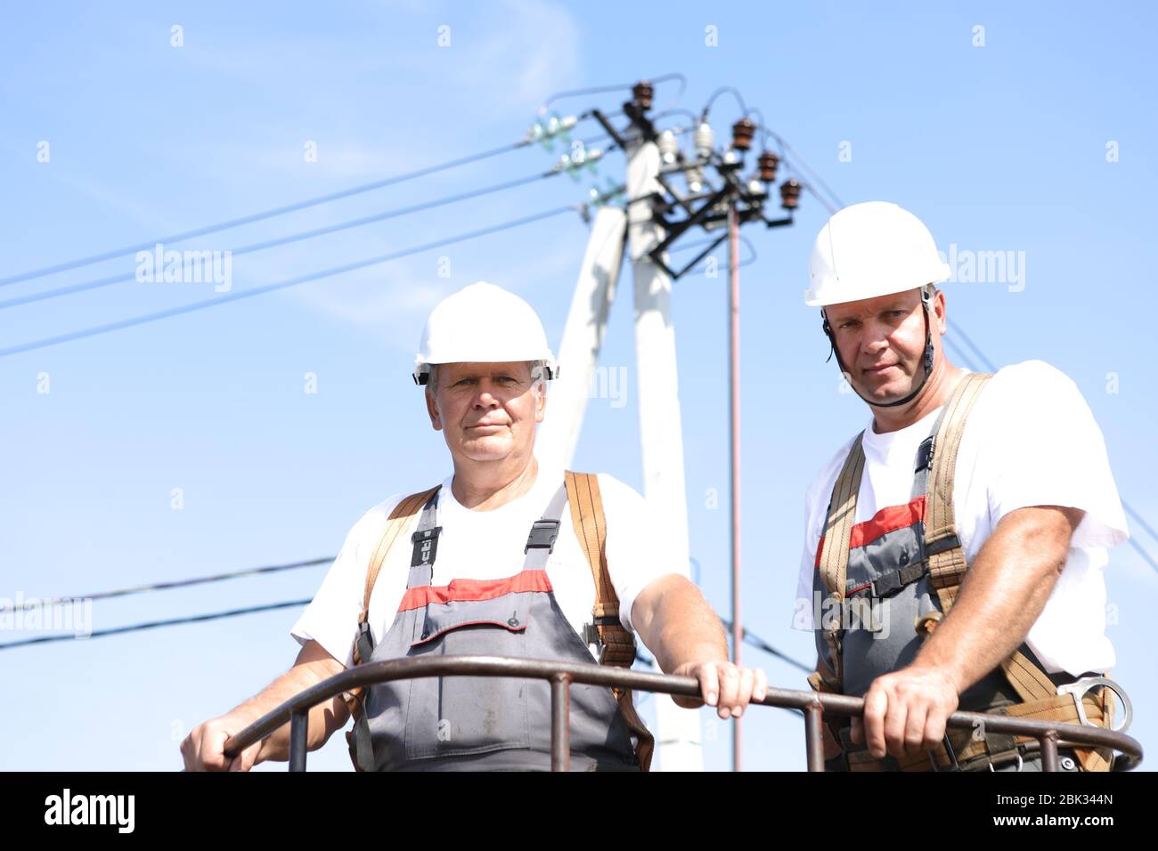 Two electrical workers on a lift. Engineers rise on a crane to repair a