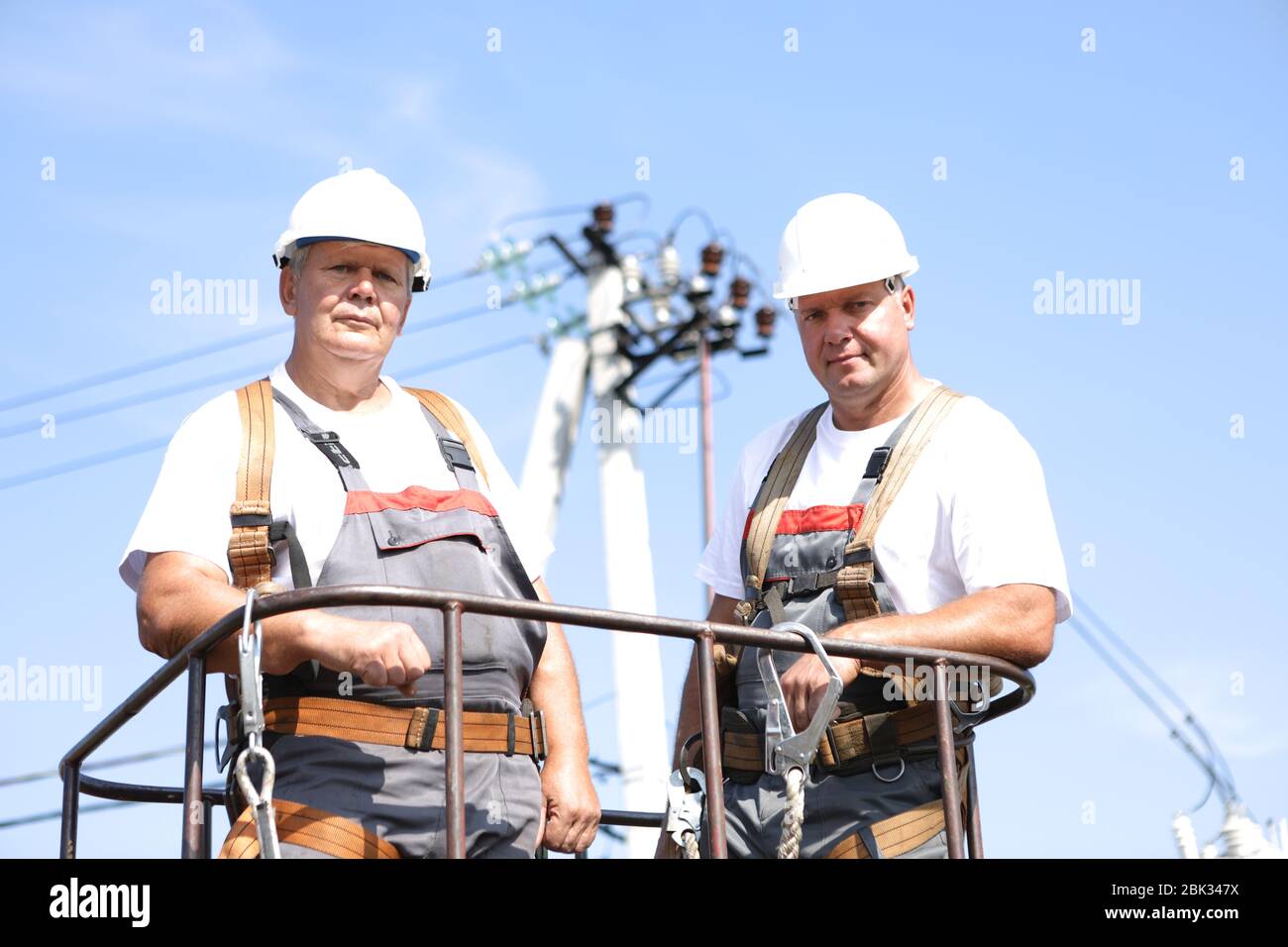Two electrical workers on a lift. Engineers rise on a crane to repair a