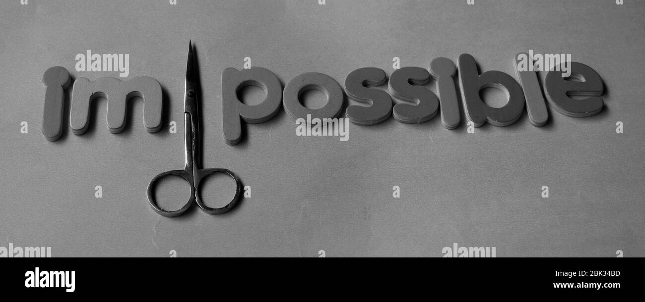 Self belief and positive concept, scissors cut off the word Impossible to read possible. From impossible to the possible. Stock Photo
