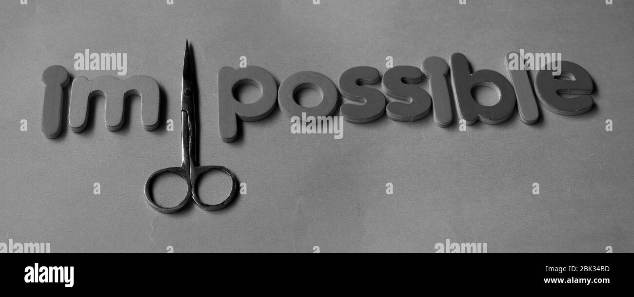 Self belief and positive concept, scissors cut off the word Impossible ...