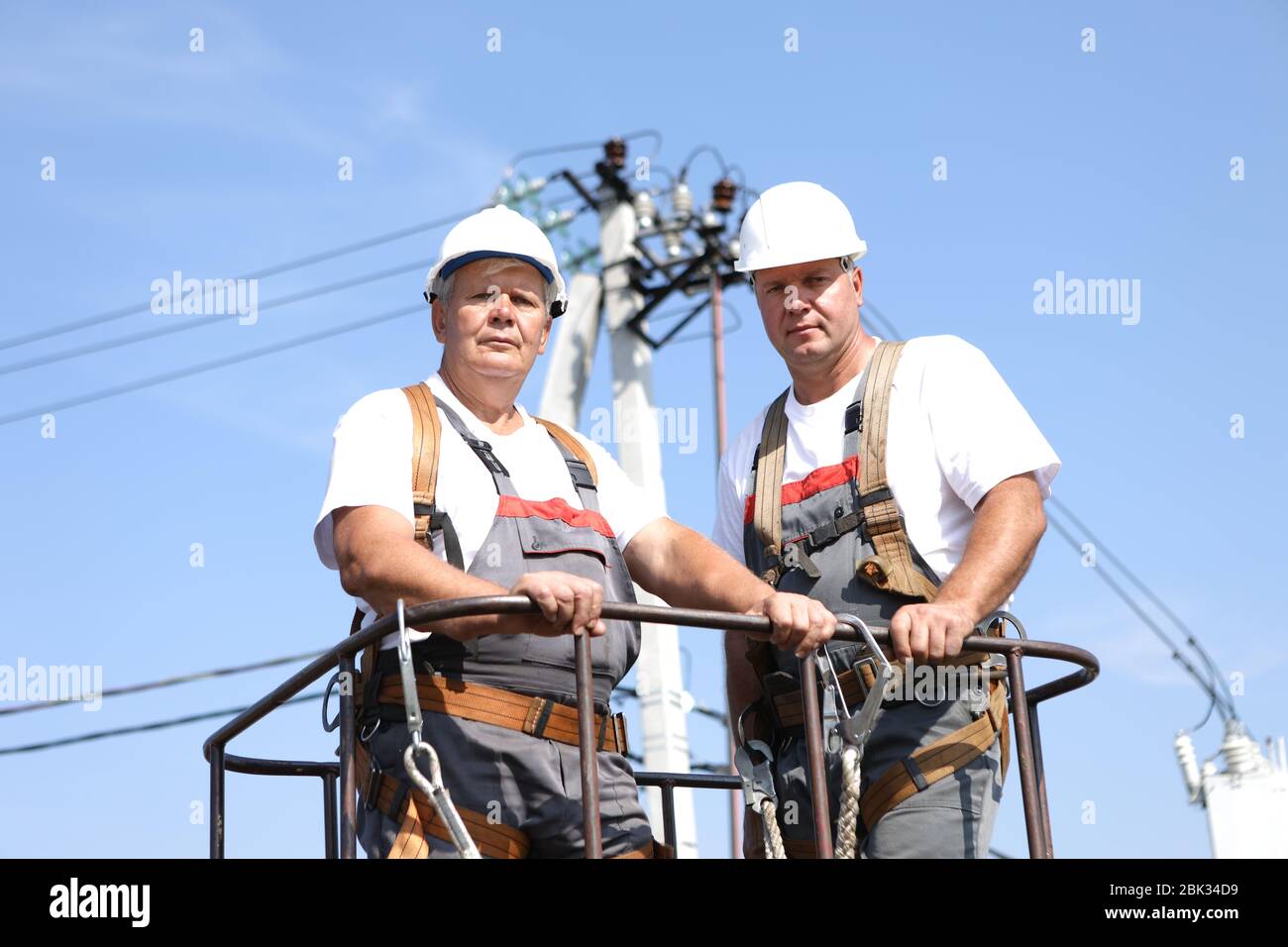 Two electrical workers on a lift. Engineers rise on a crane to repair a
