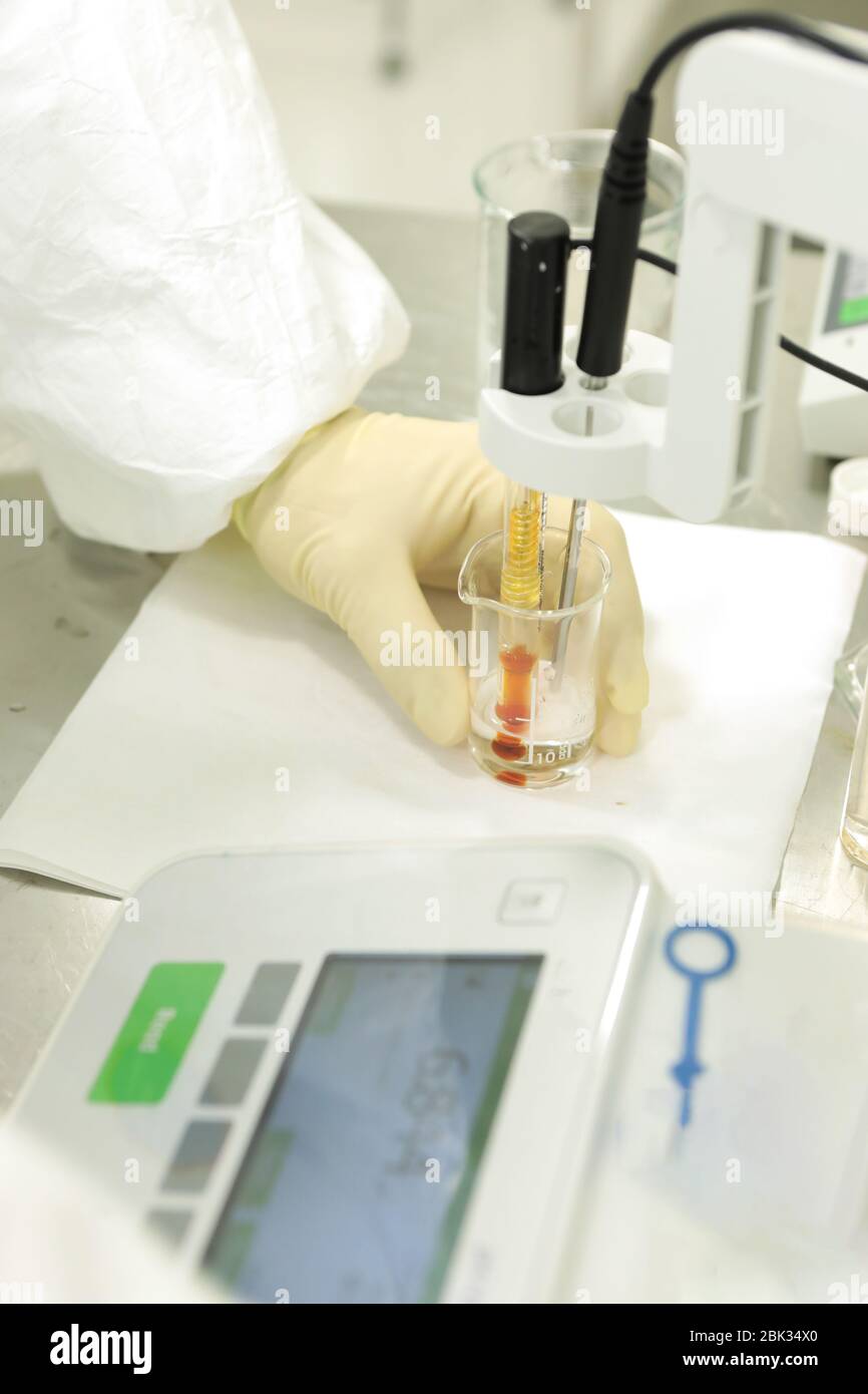 A chemist conducts a study of the stiffness of the solution. Laboratory PH measurement. A device for measuring PH chemically. Modern equipment for Stock Photo
