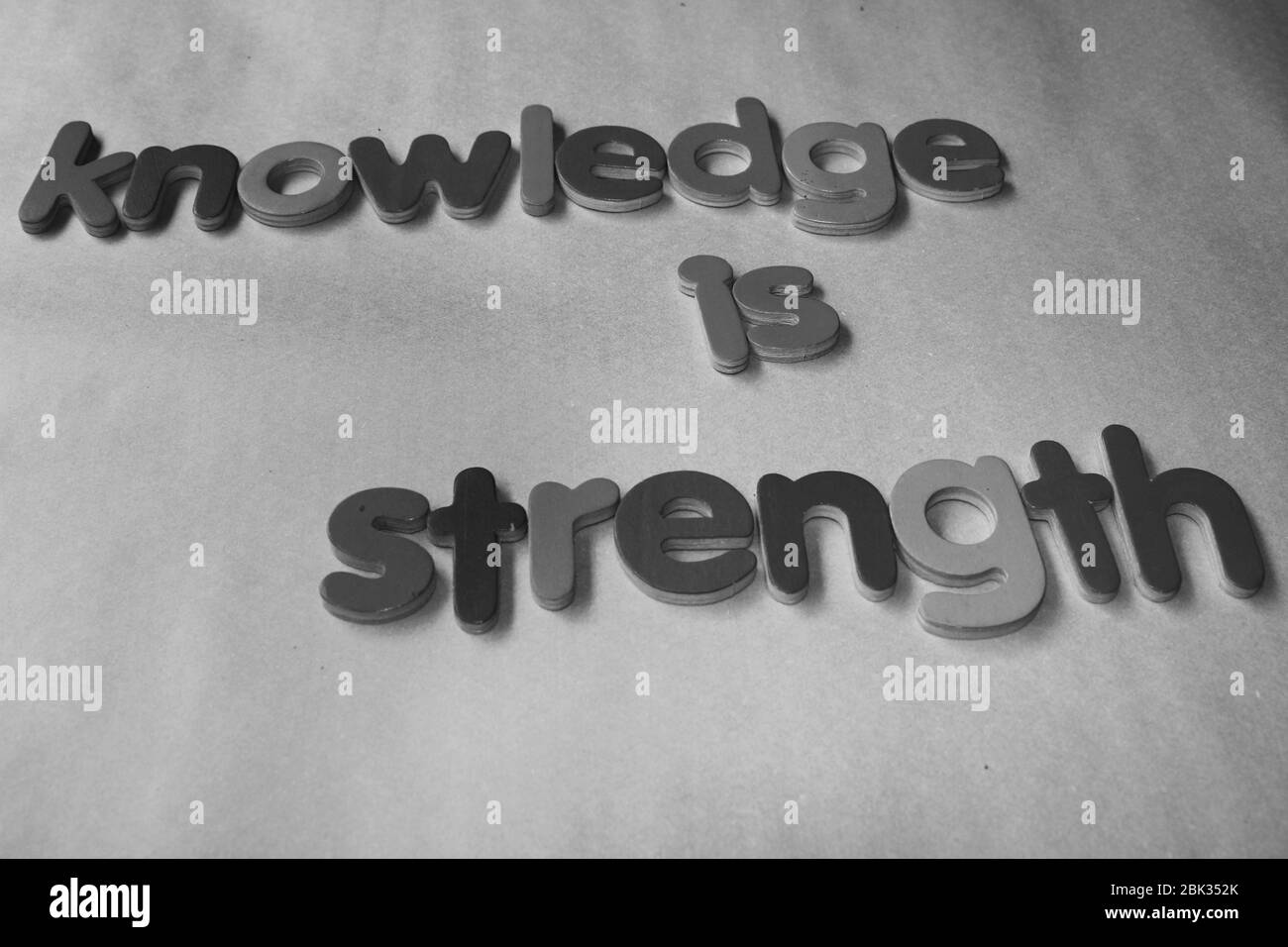 Knowledge is strength. Knowledge is strength written on wall by using the wooden English alphabet. Stock Photo