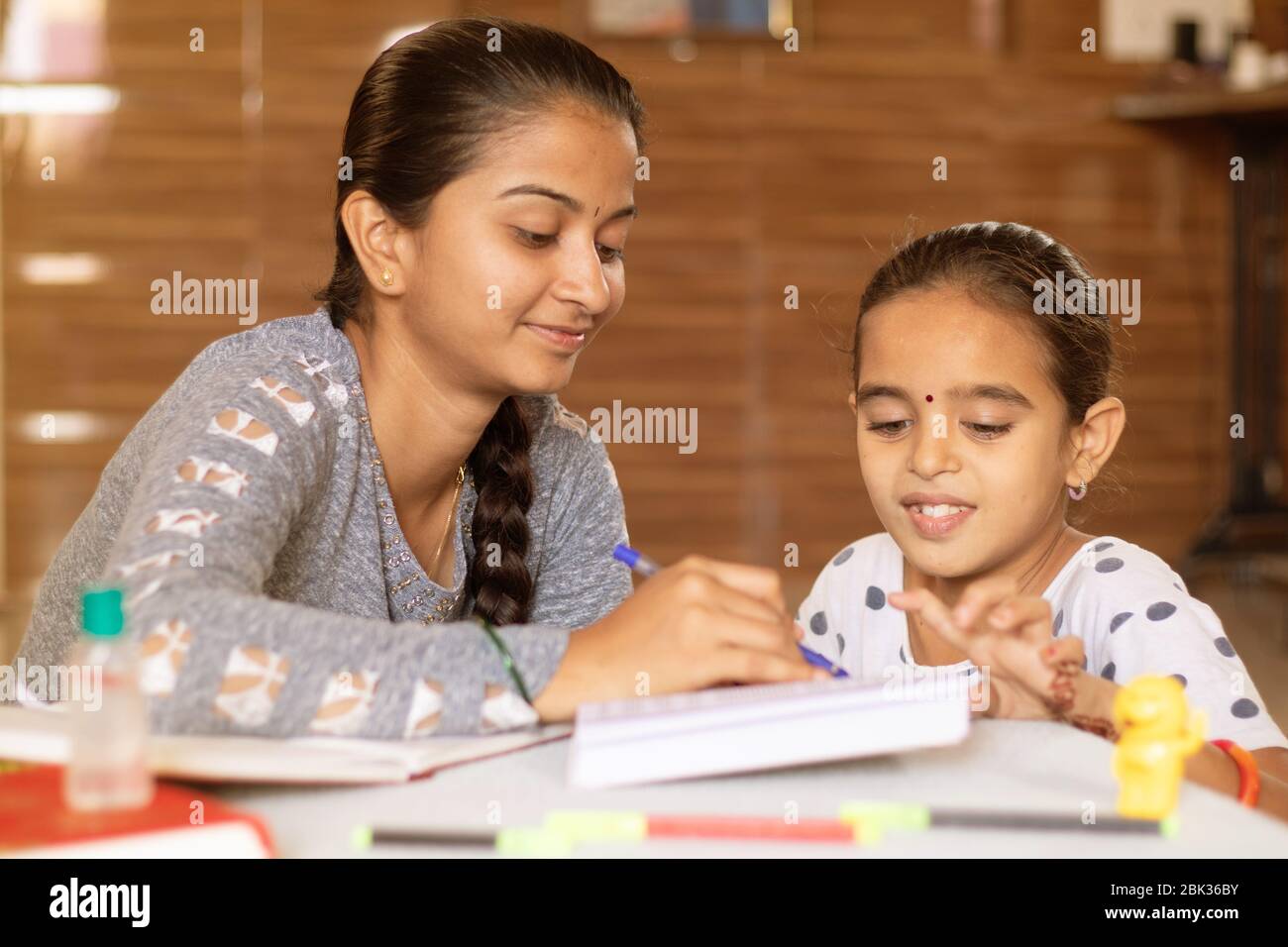 young girl teaching her sister at home - conept of homeschooling during coronavirus or covid-19 lockdown pandemic. Stock Photo