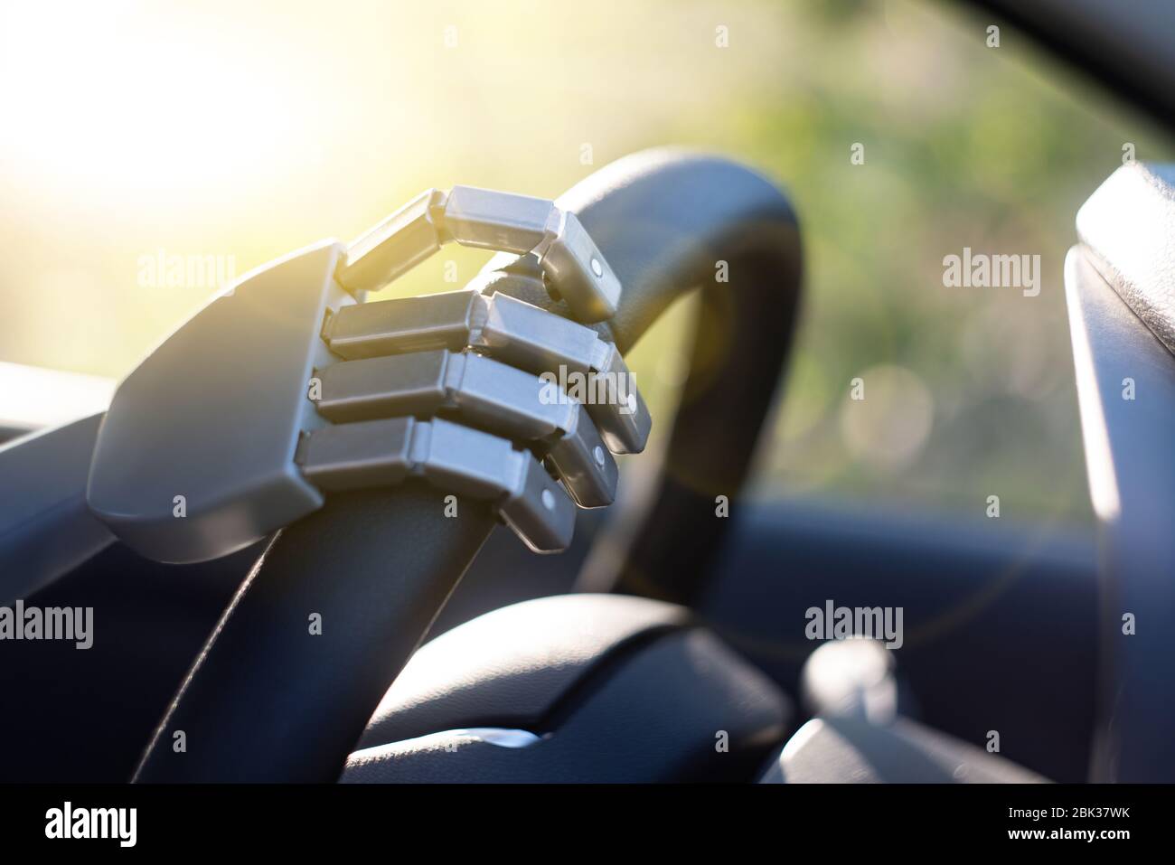 Robot arm on a steering wheel. Artificial intelligence drives a car. Autonomous vehicle concept. Stock Photo