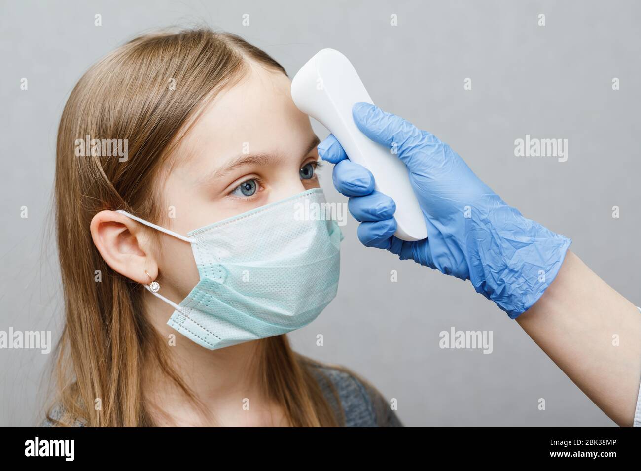 Pediatrician using infrared forehead thermometer (thermometer gun) to