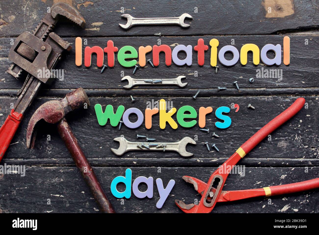 International workers' day text in red color on wooden background with construction repair tools. Labor day concept sign. International workers' day. Stock Photo