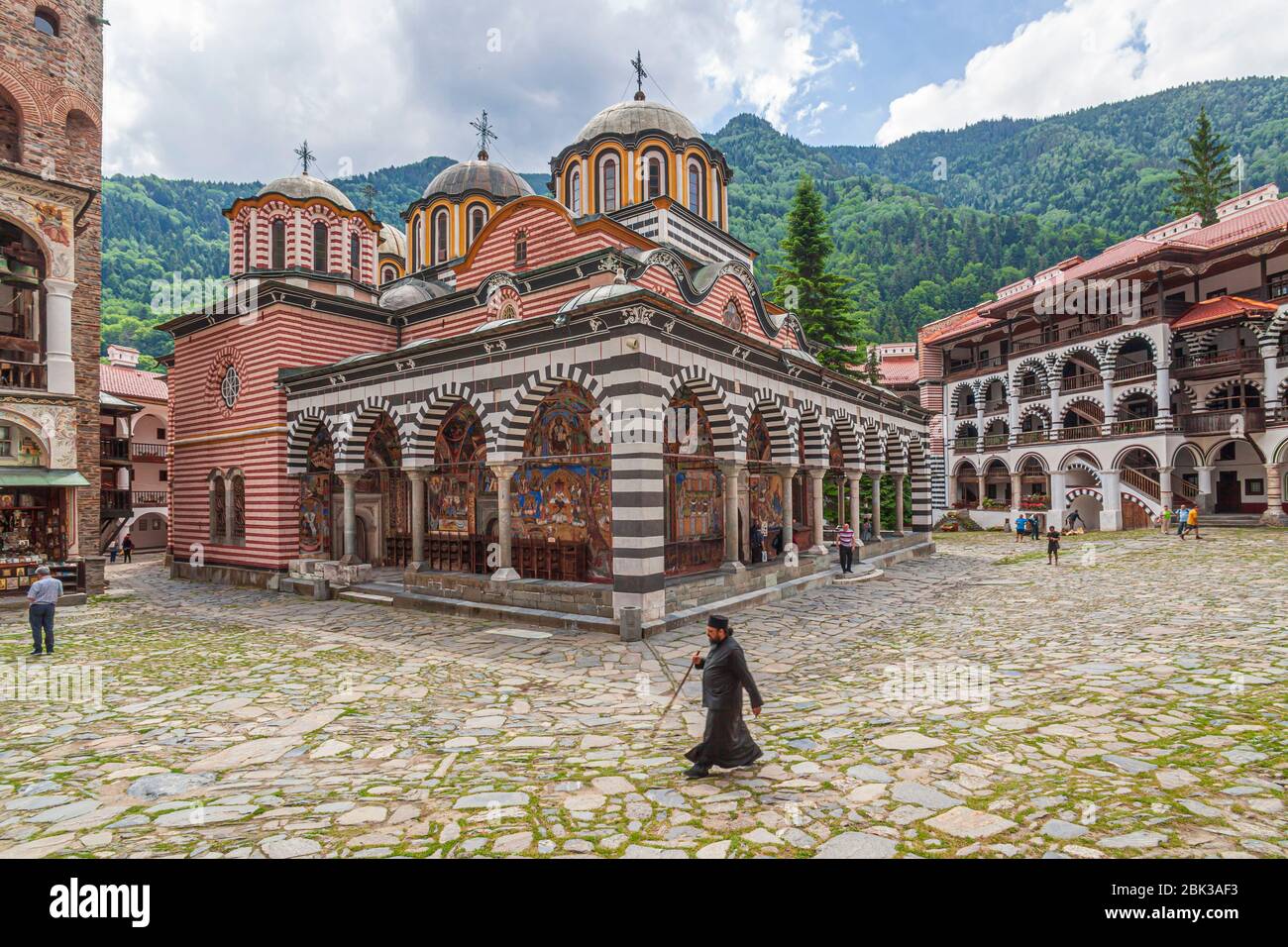 orthodox monk in front of rila monestary in bulgaria walking across the courtyard Stock Photo