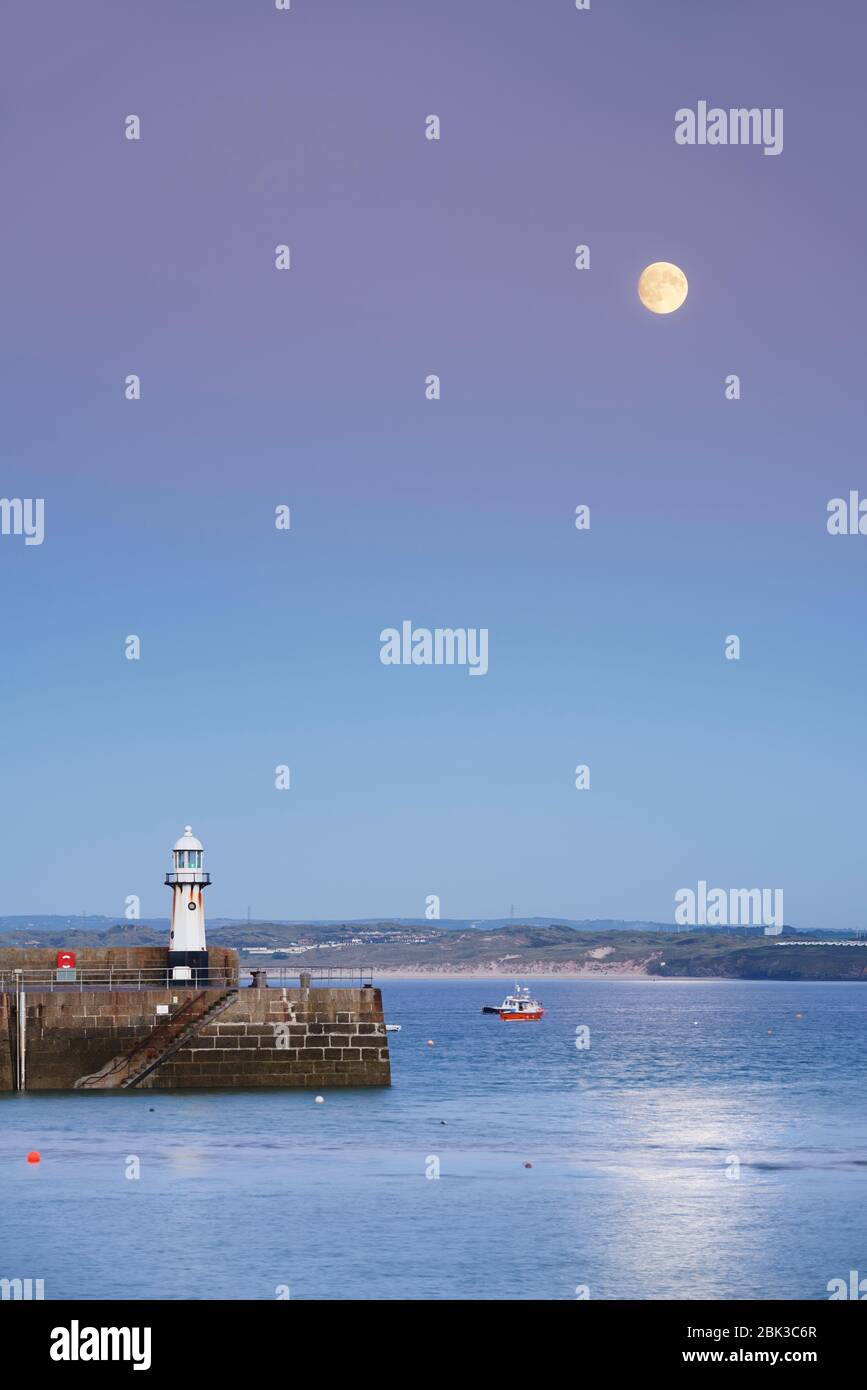 Twilight at Smeaton's Pier St Ives harbour with a full moon rising Stock Photo