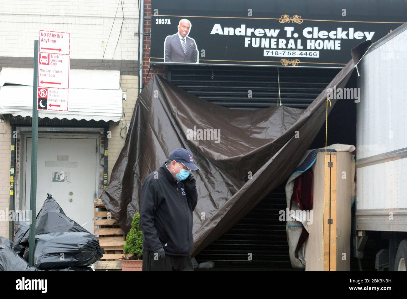 New York, New York, USA. 30th Apr, 2020. This official representing New York City stands on the phone in front of the Andrew T. Cleckley Funeral Home in Brooklyn where bodies non properly cared are removed. 60 corpses were stored in 4 non-refregerated rented trucks lining the street nearby stores. Neighbors reported a foul smell still persistent and fluids dripping from the trucks. Some remains were also found lying on the facilityÃ¢â‚¬â„¢s floor. The funeral home was overwhelmed by COVID-19 deaths. Credit: Marie Le Ble/ZUMA Wire/Alamy Live News Stock Photo